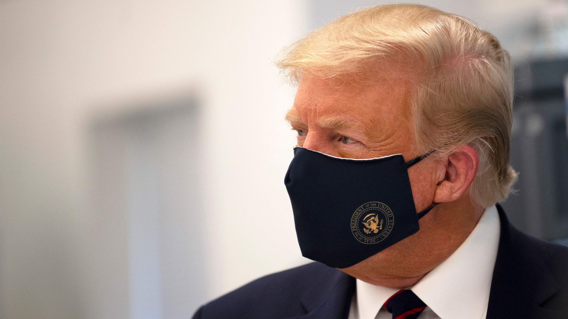 President Trump wearing a black face mask with the presidential seal