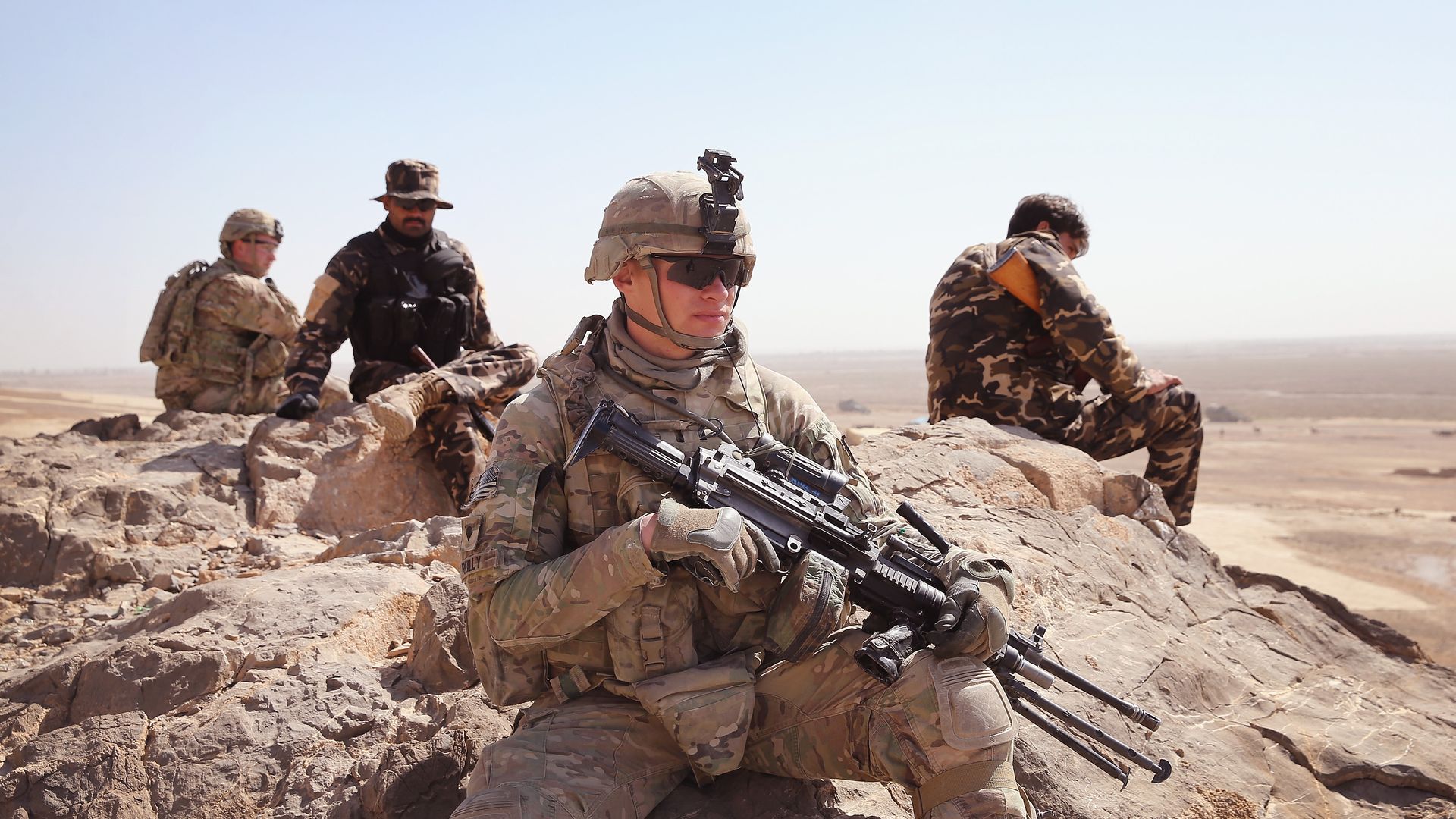 US troops resting on a rock in Afghanistan 