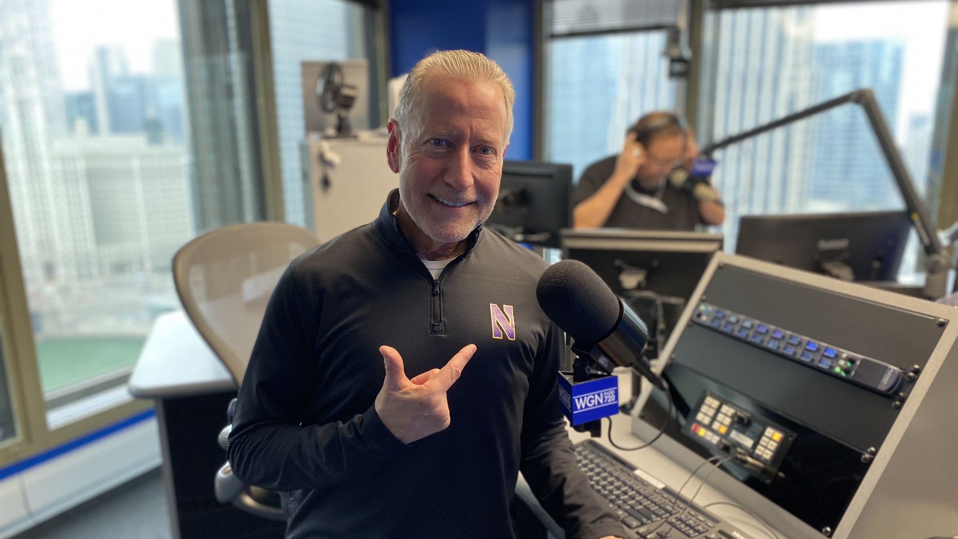 Photo of a man behind a microphone in a radio studio