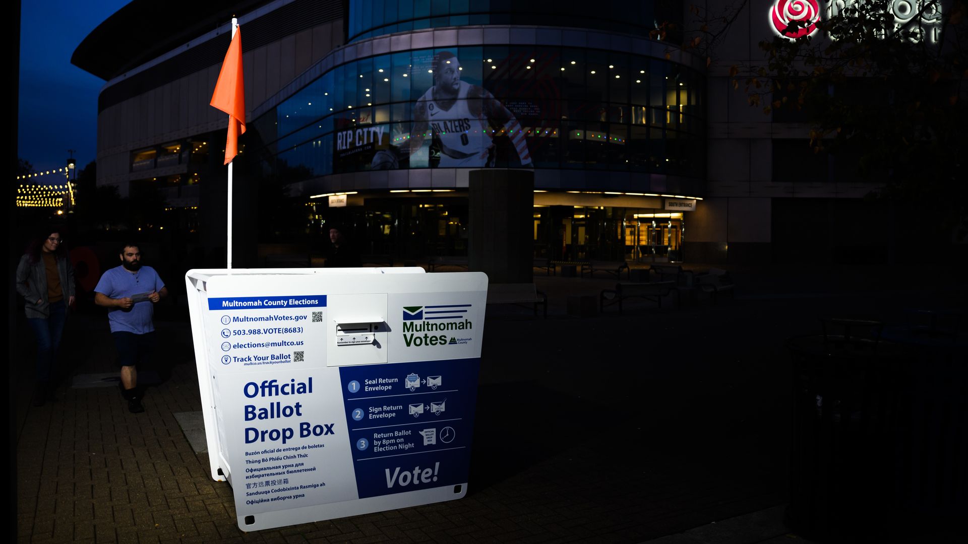 A ballot drop box is seen in front of a large arena.