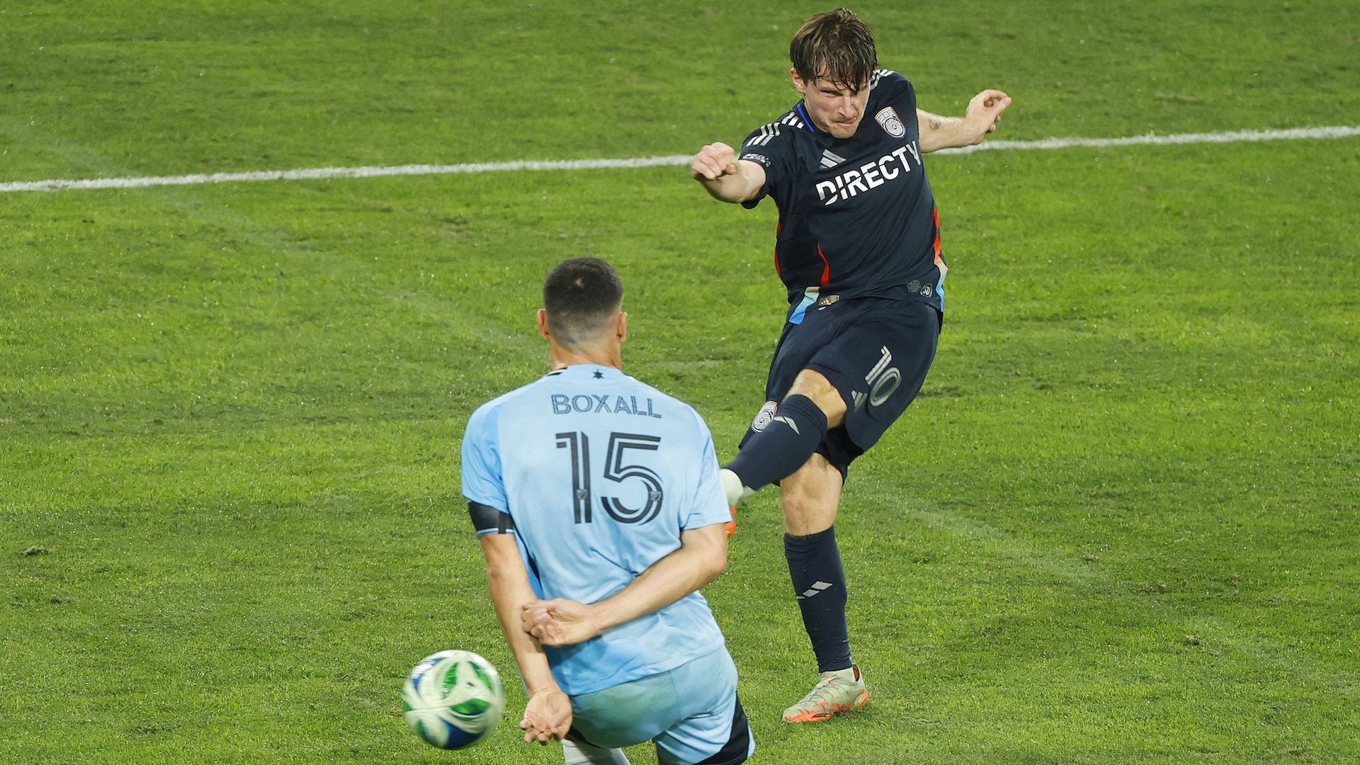 SDFC player Anders Dreyer kicks a ball past a defender to score. 