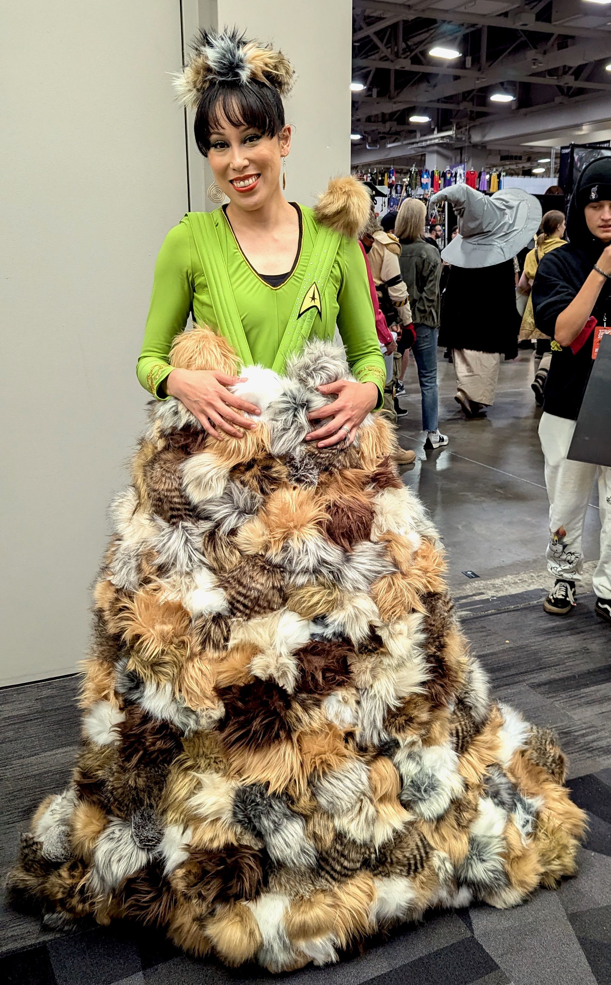 A woman costumed as Captain Kirk being covered with furry Tribbles.