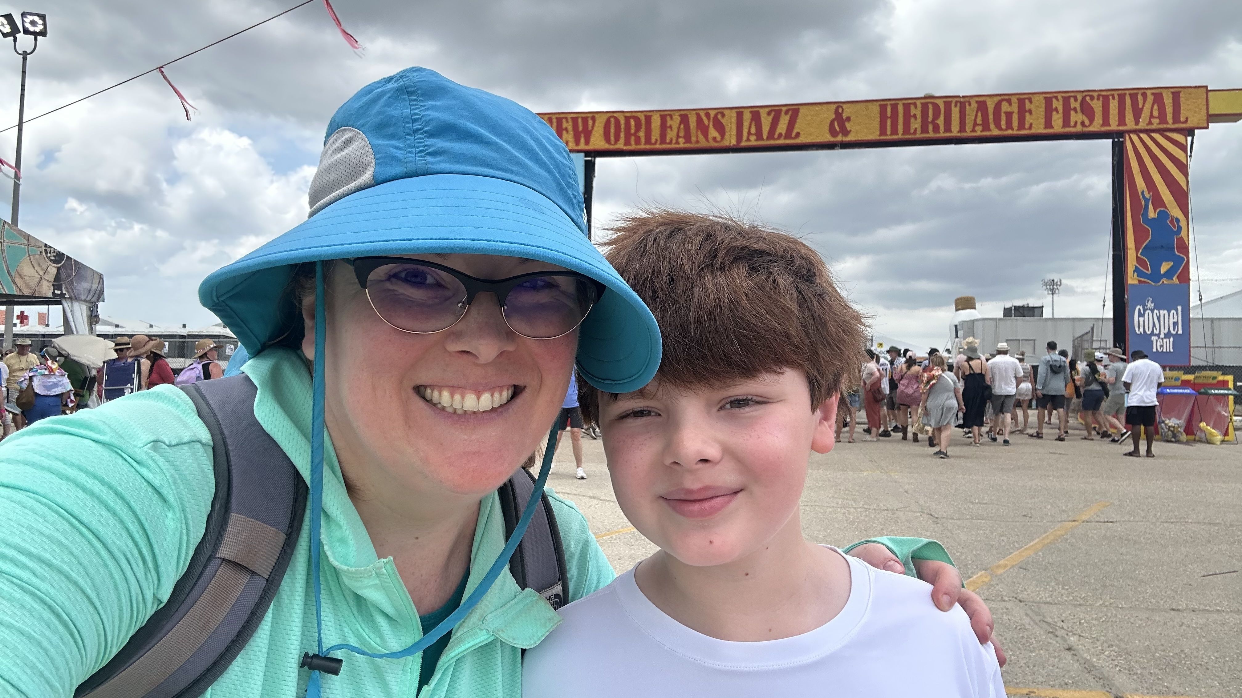 Photo shows a woman and boy with the Jazz Fest gates.
