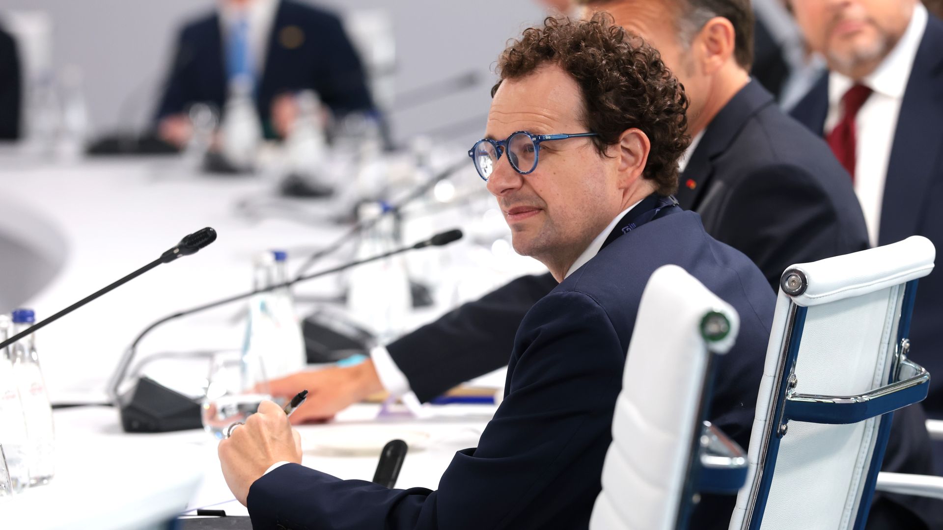 Anthropic CEO Dario Amodei, seated in front of a microphone at a round table.