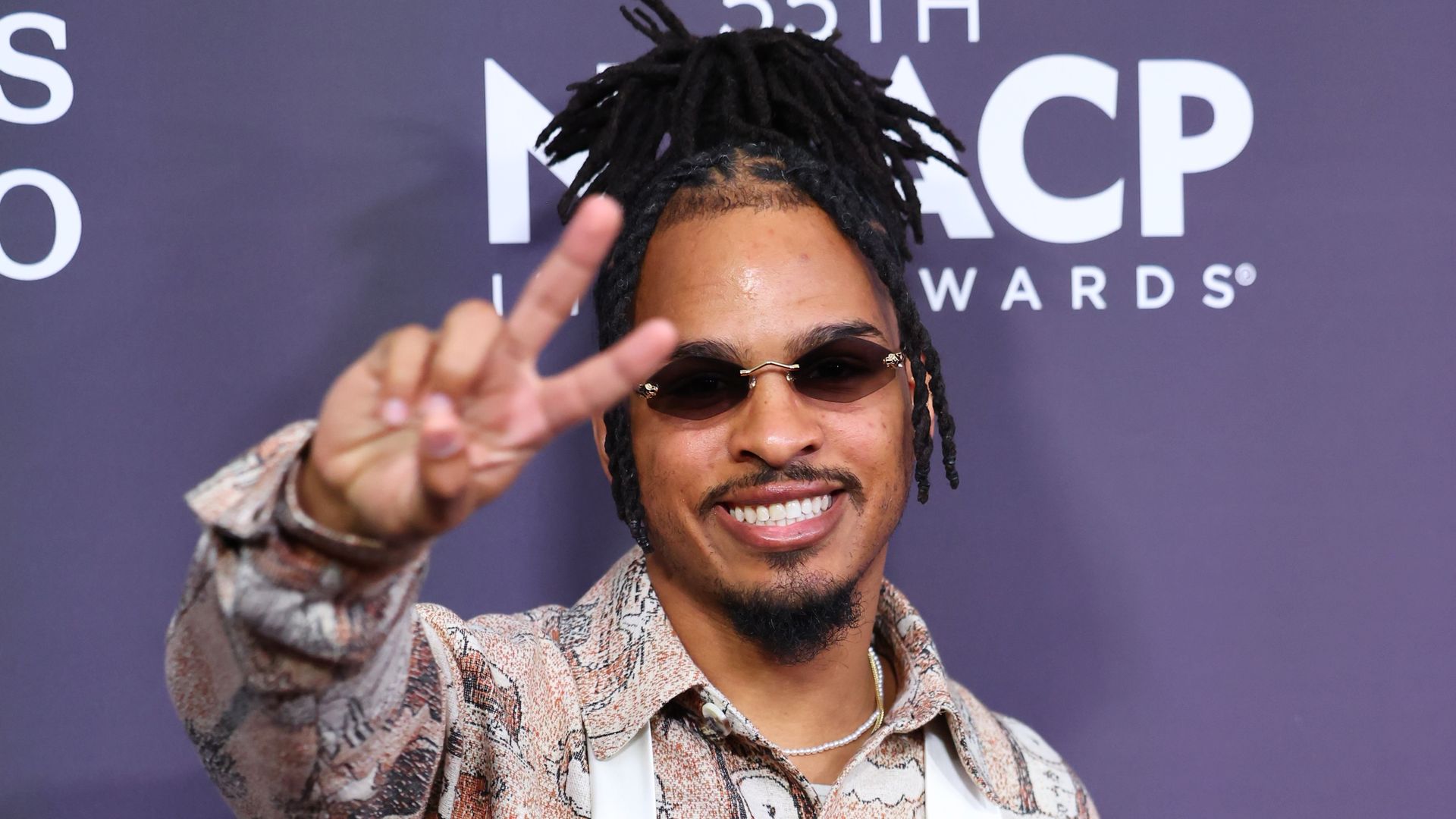 Photo shows Keith Lee on the red carpet in sunglasses and making a peace sign.