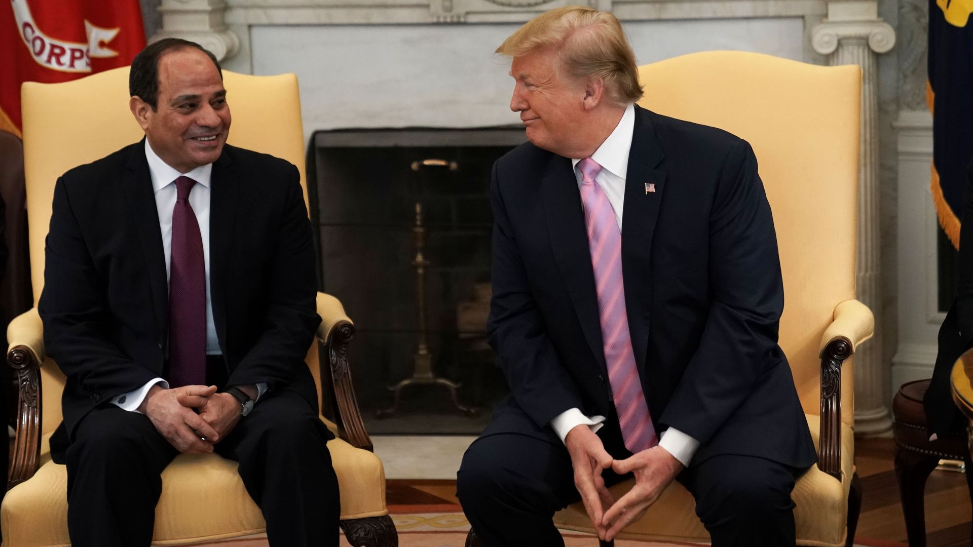 In this image, Trump sits on the right next to Abdel Fattah el-Sisi of Egypt. Trump turns to face Abdel and is smiling at him.