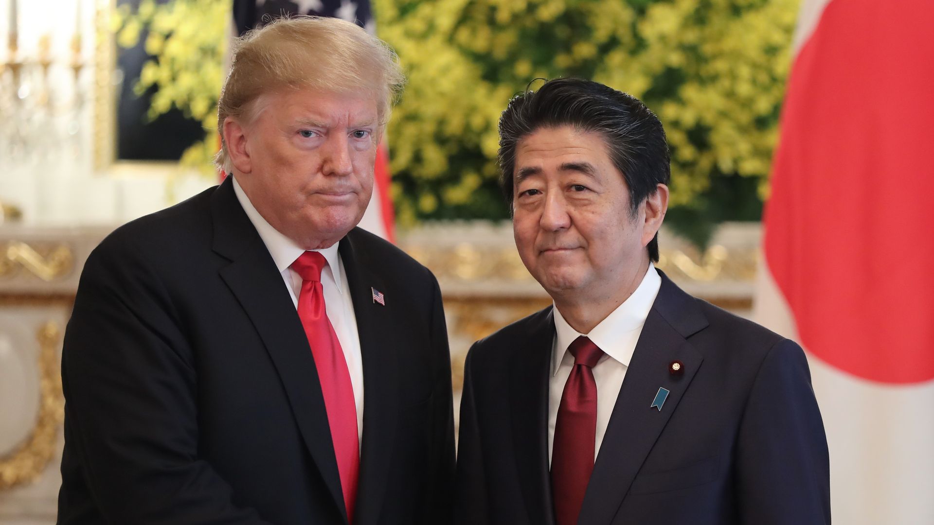 President Donald Trump shakes hands with Japan's Prime Minister Shinzo Abe (R) after their bilateral meeting at Akasaka Palace in Tokyo.