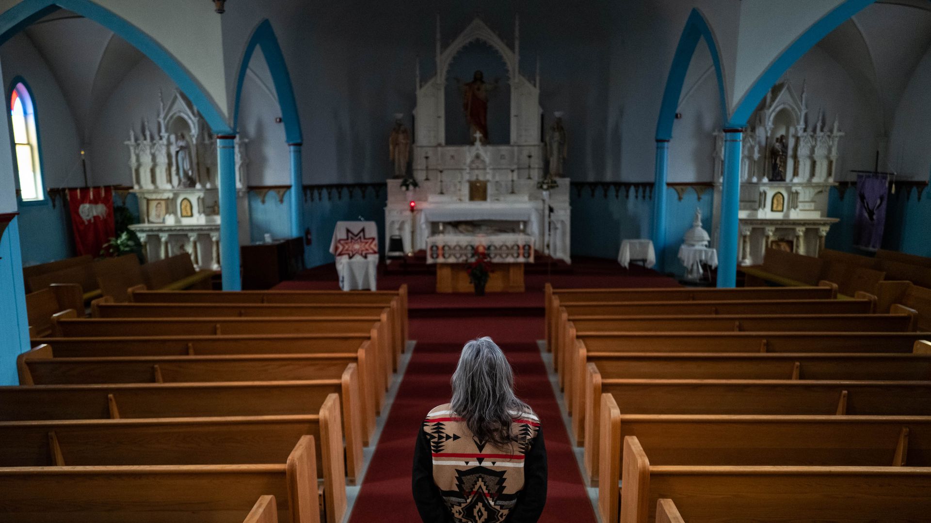 Clarita Vargas, 64, one of the survivors of St. Mary's Mission, an Indian boarding school, stands in the St. Mary's church on the Colville Reservation in Omak, Washington, in February 2024. 