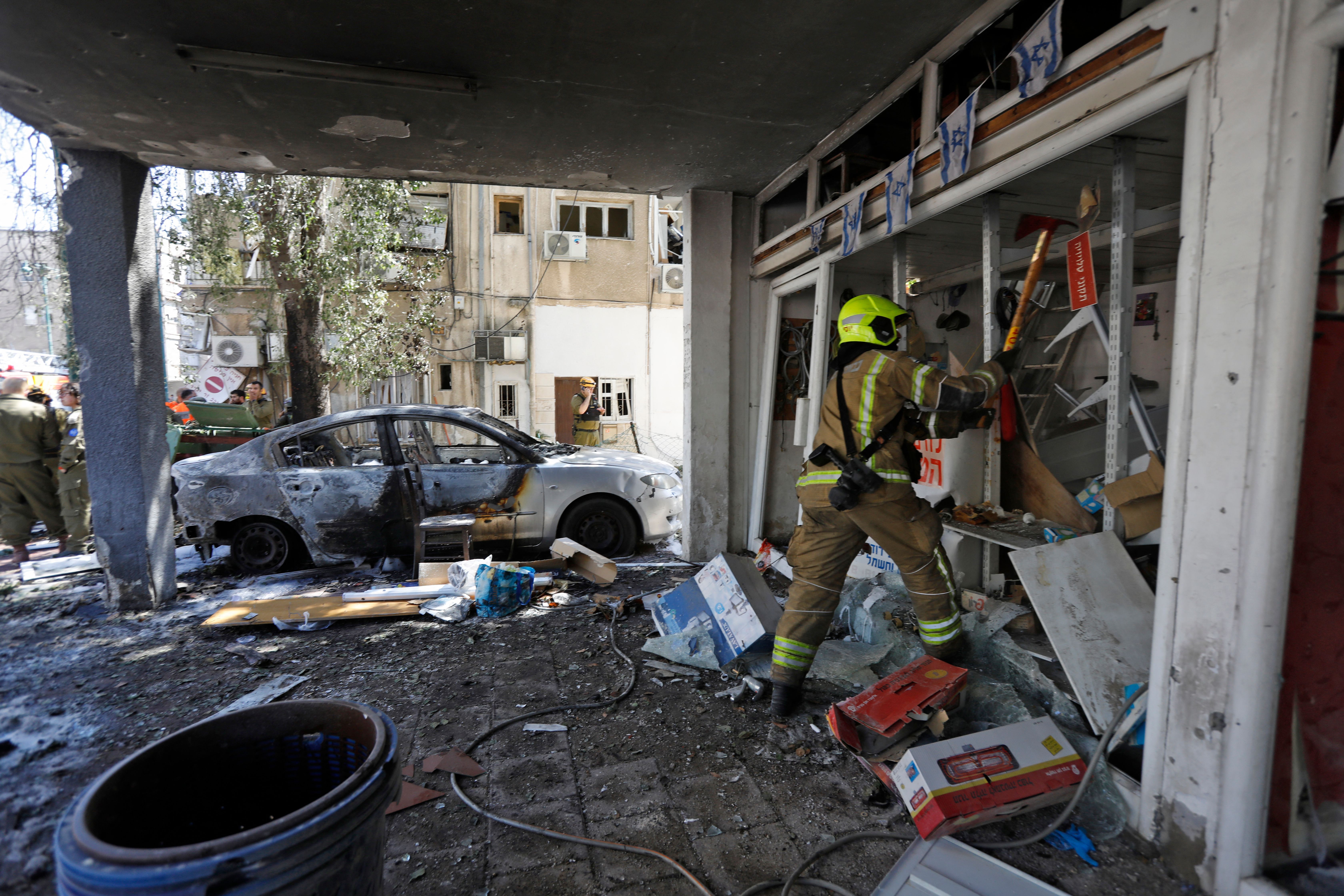 A member of Israeli emergency services works on a site hit by a rocket in Ramat Gan near the coastal city of Tel Aviv, on May 15