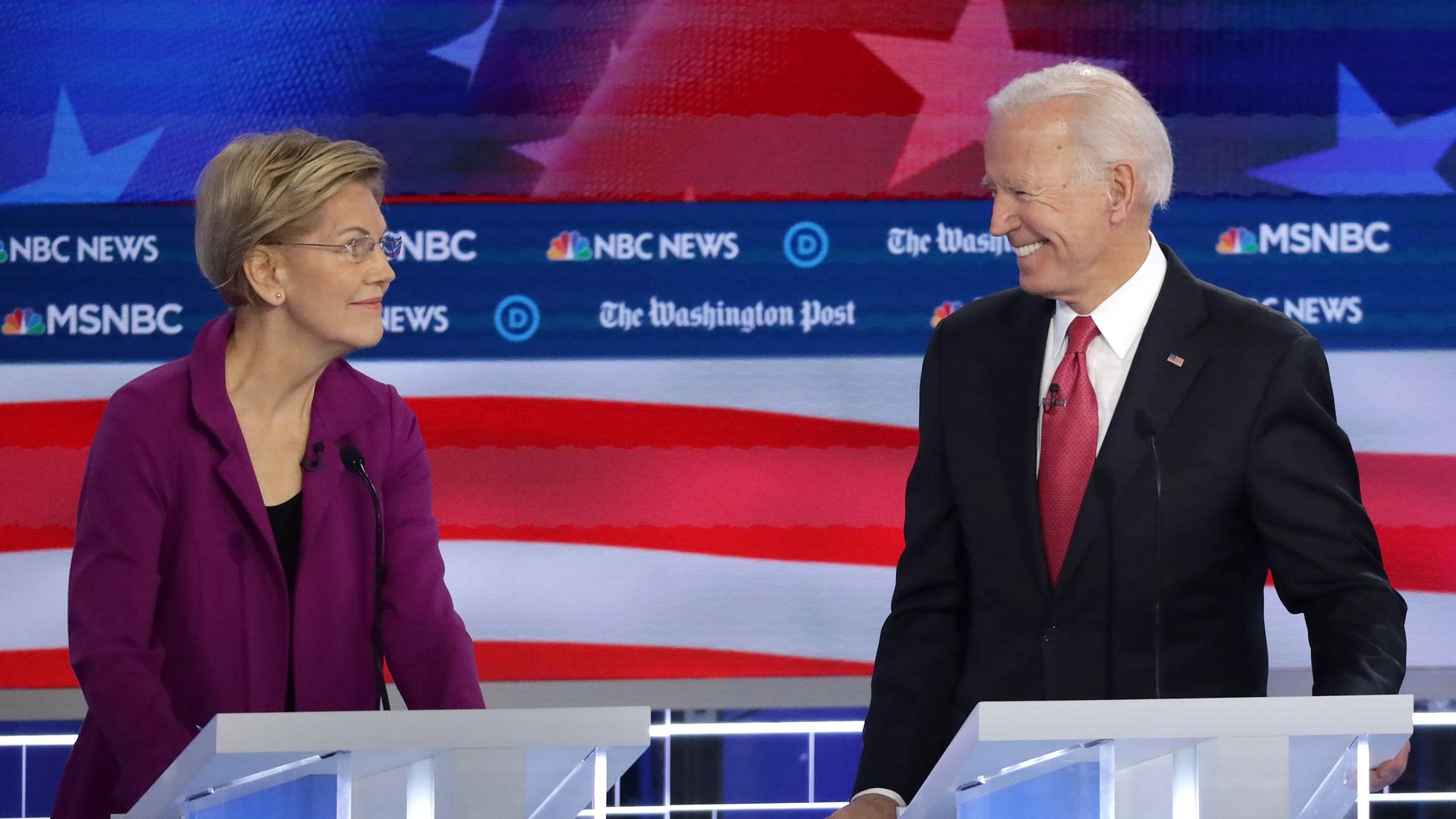 en. Elizabeth Warren (D-MA) (L) and former Vice President Joe Biden smile at each other 