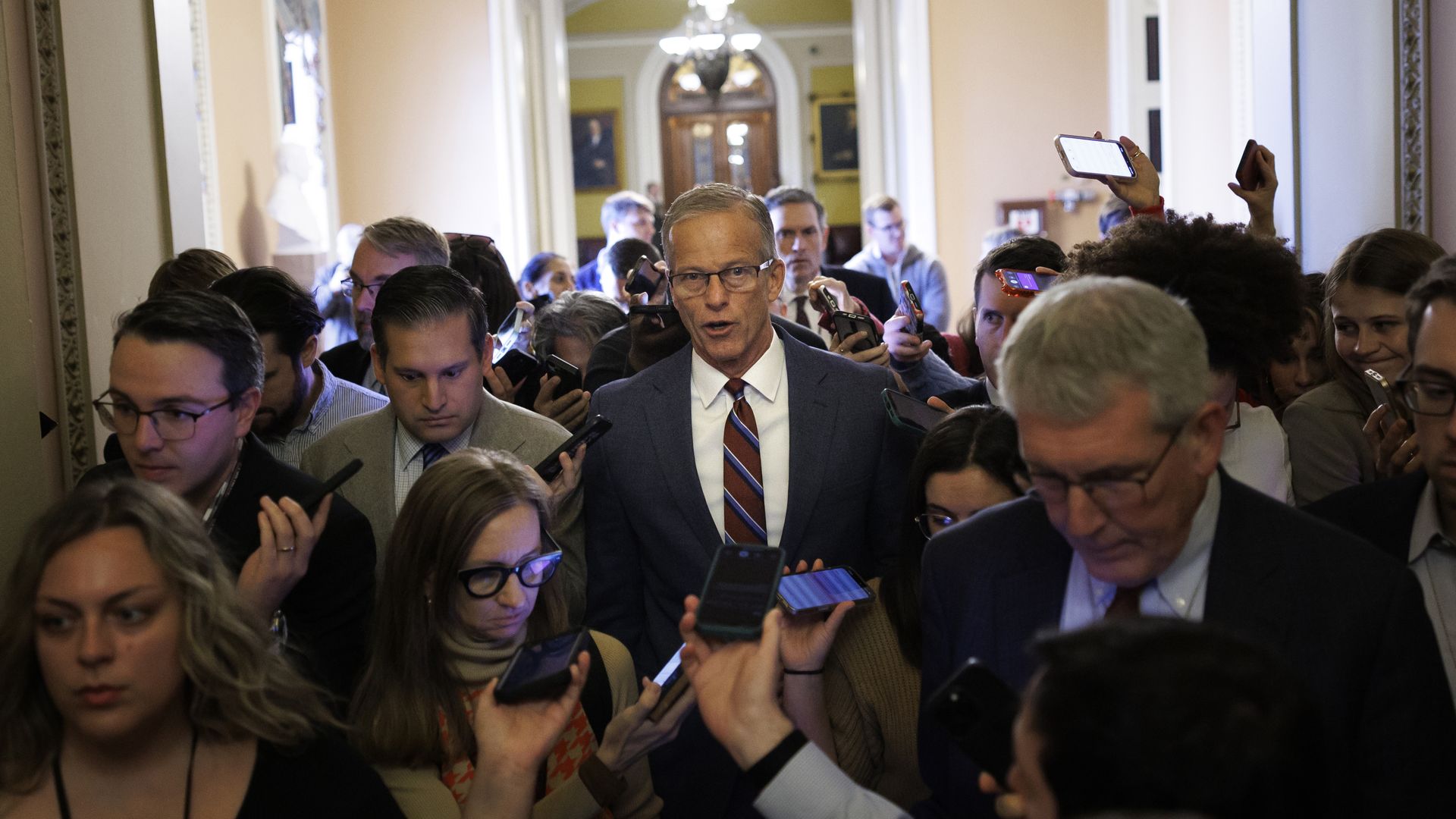 Senate Majority Leader John Thune (R-SD) speaks to reporters while walking to his office 