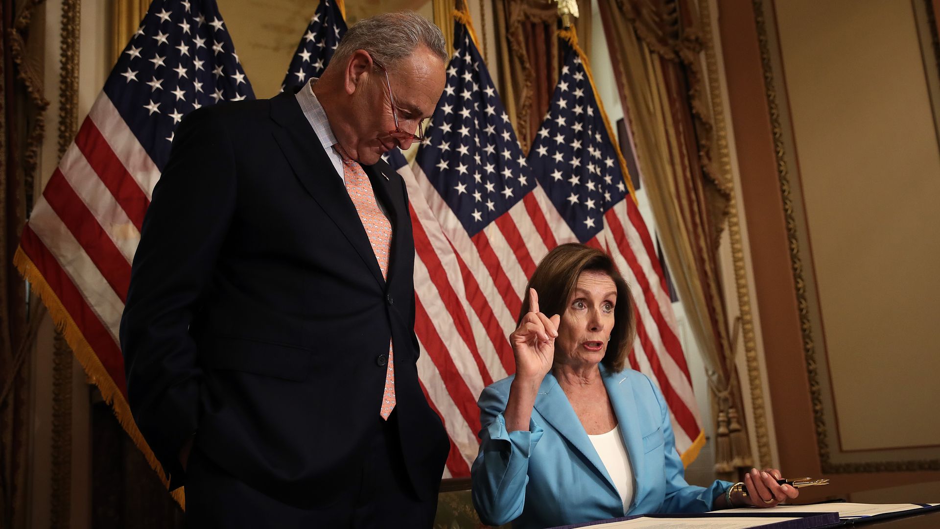 Senate Minority Leader Chuck Schumer (L) (D-NY) and Speaker of the House Nancy Pelosi (R) (D-CA) participate in a signing ceremony in Washington, DC.