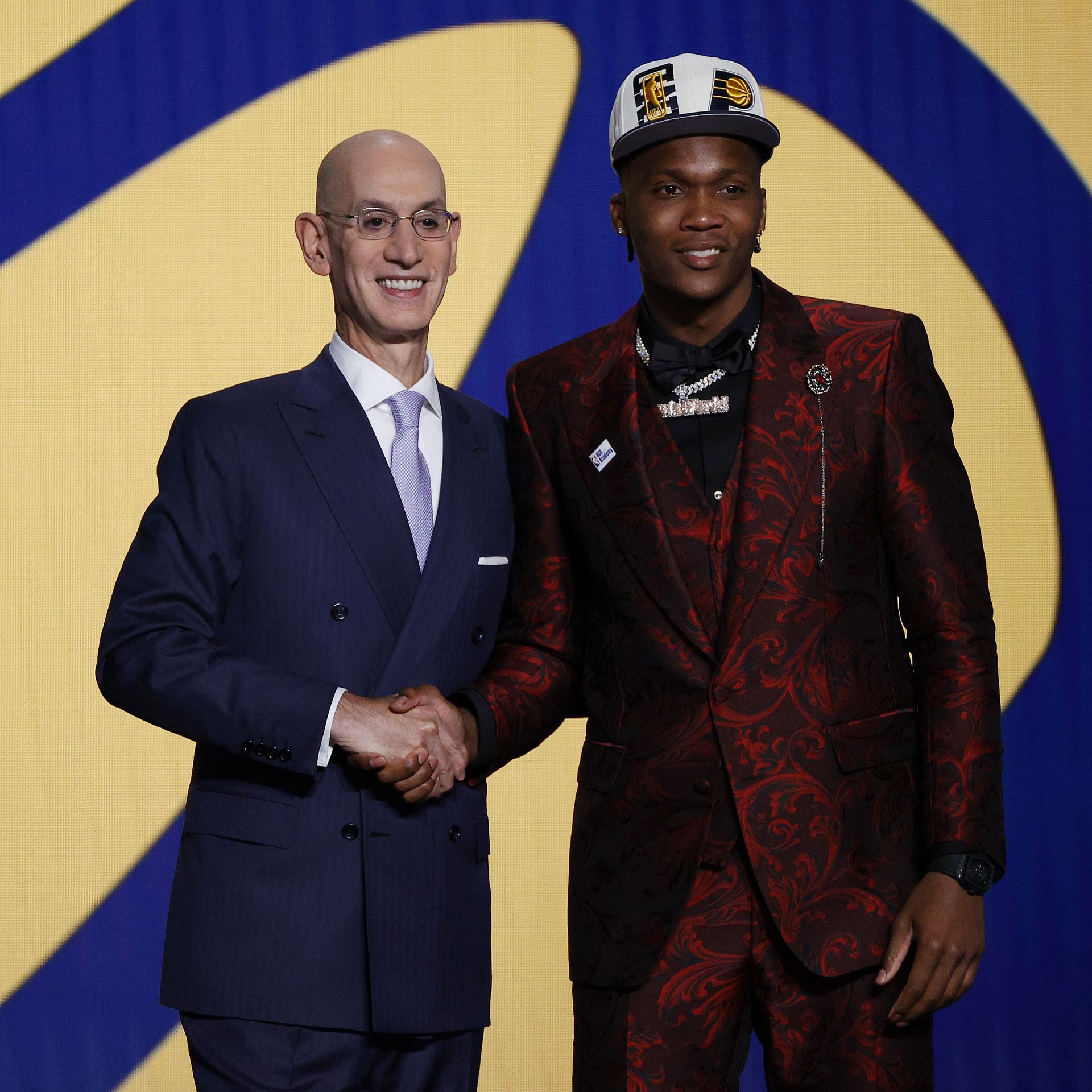 NBA commissioner shaking hands with a player during the draft.
