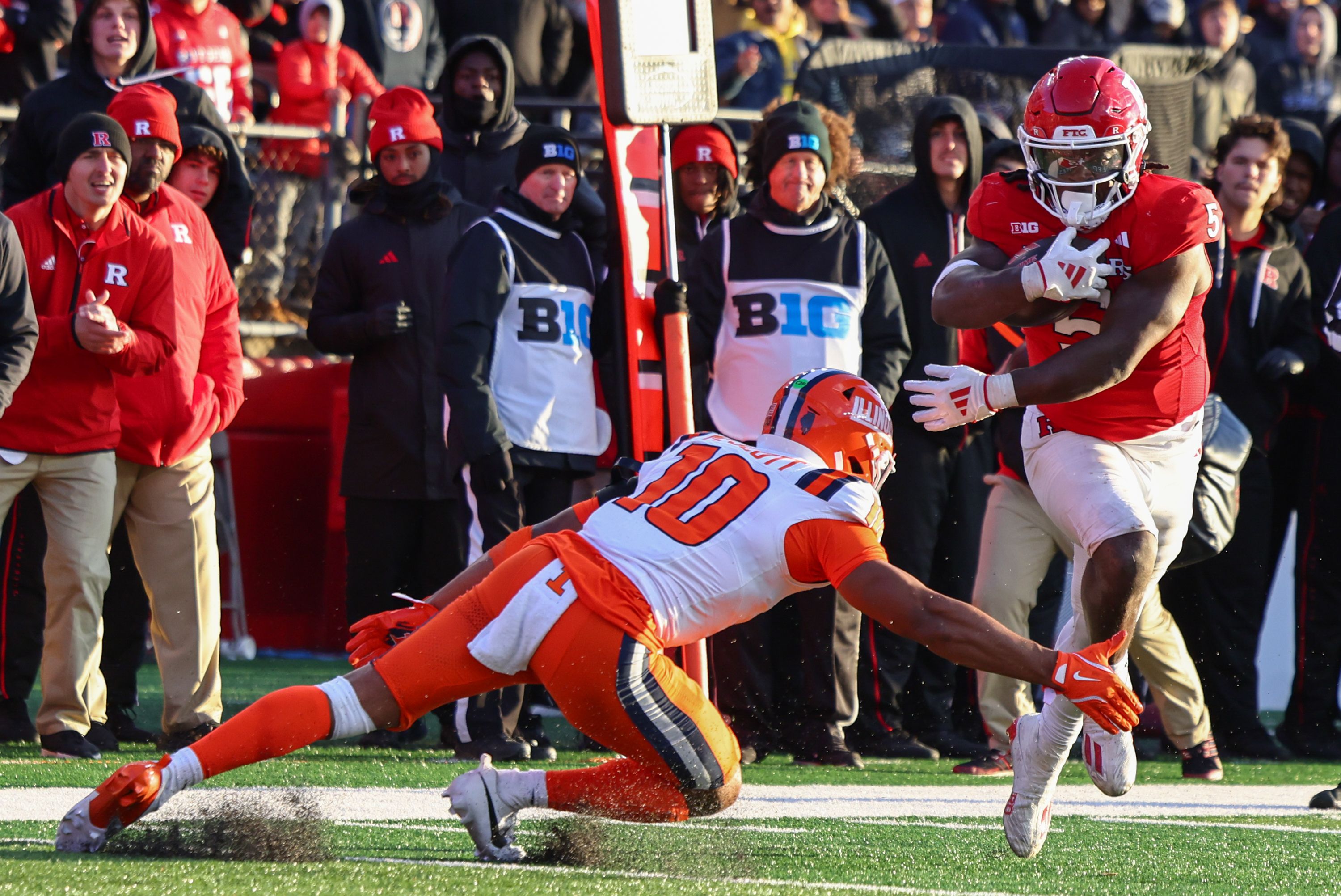 Photo of a football player avoiding a tackle on a football field. 
