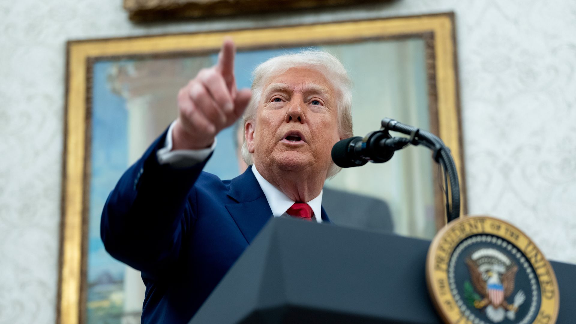Trump points as he answers reporters' questions in the White House.