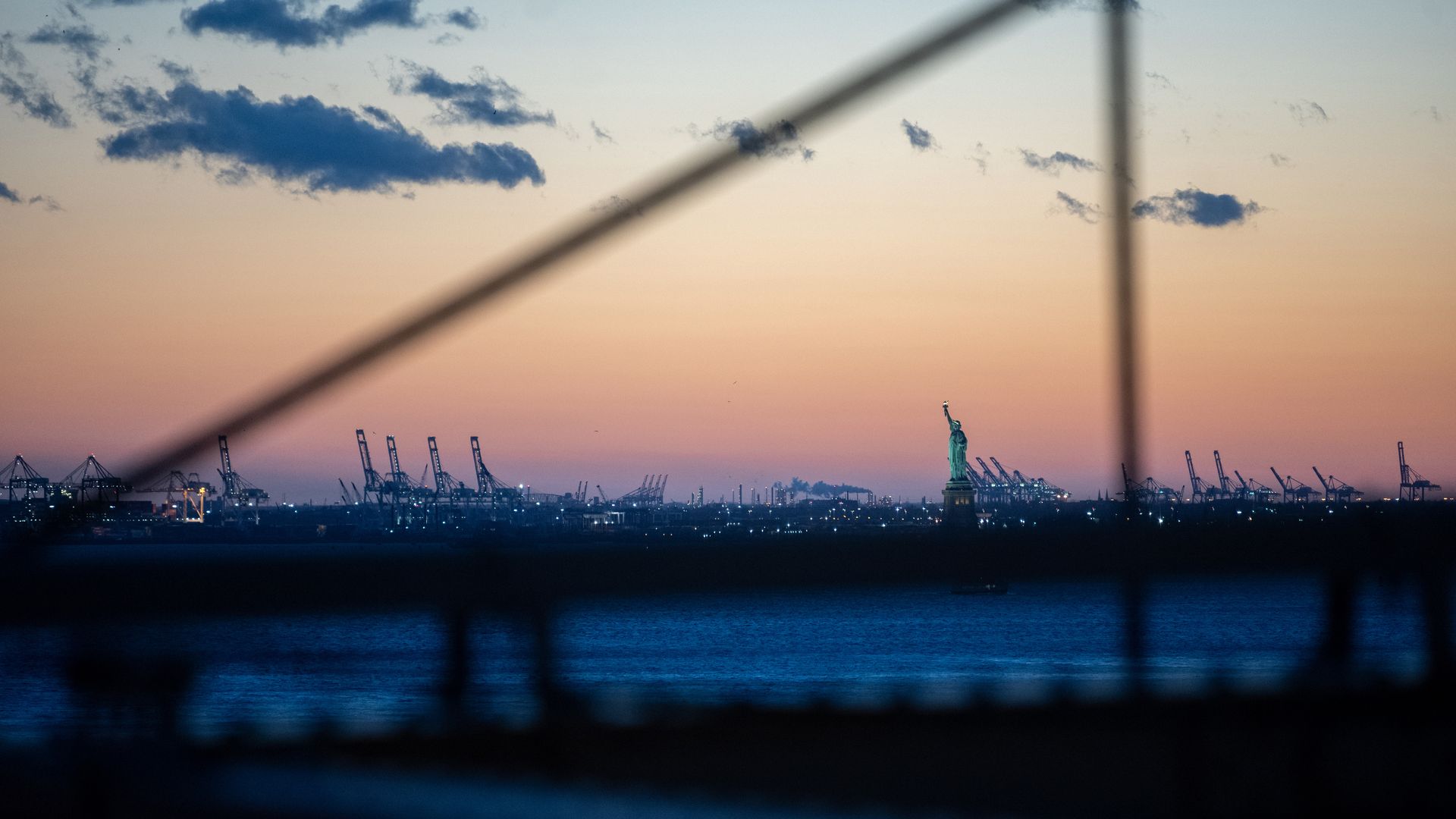 A view of The Statue of Liberty during the first sunset after the clocks changed for Daylight Savings as seen from the Brooklyn Bridge on March 14, 2021 in the Brooklyn borough of New York City. 