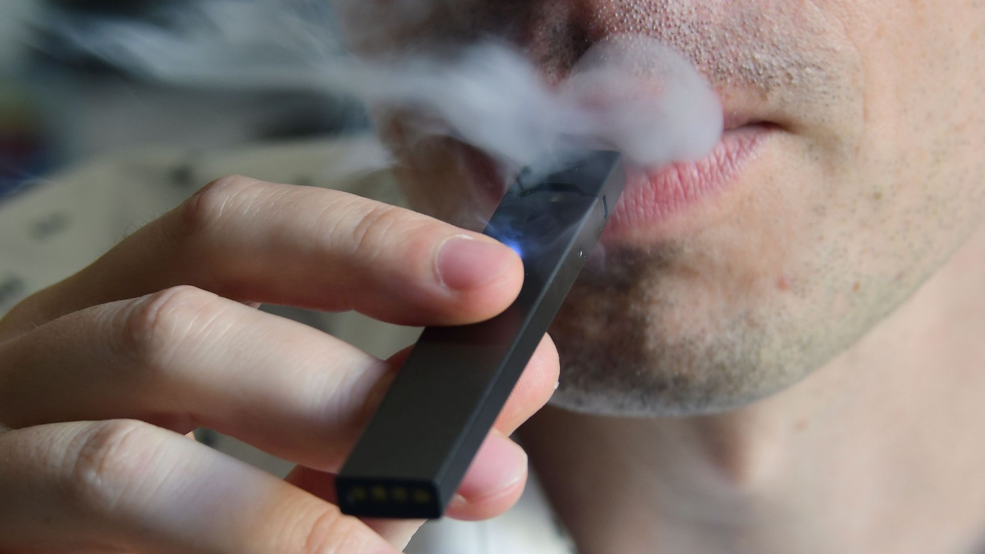A man vaping using a Juul pen.