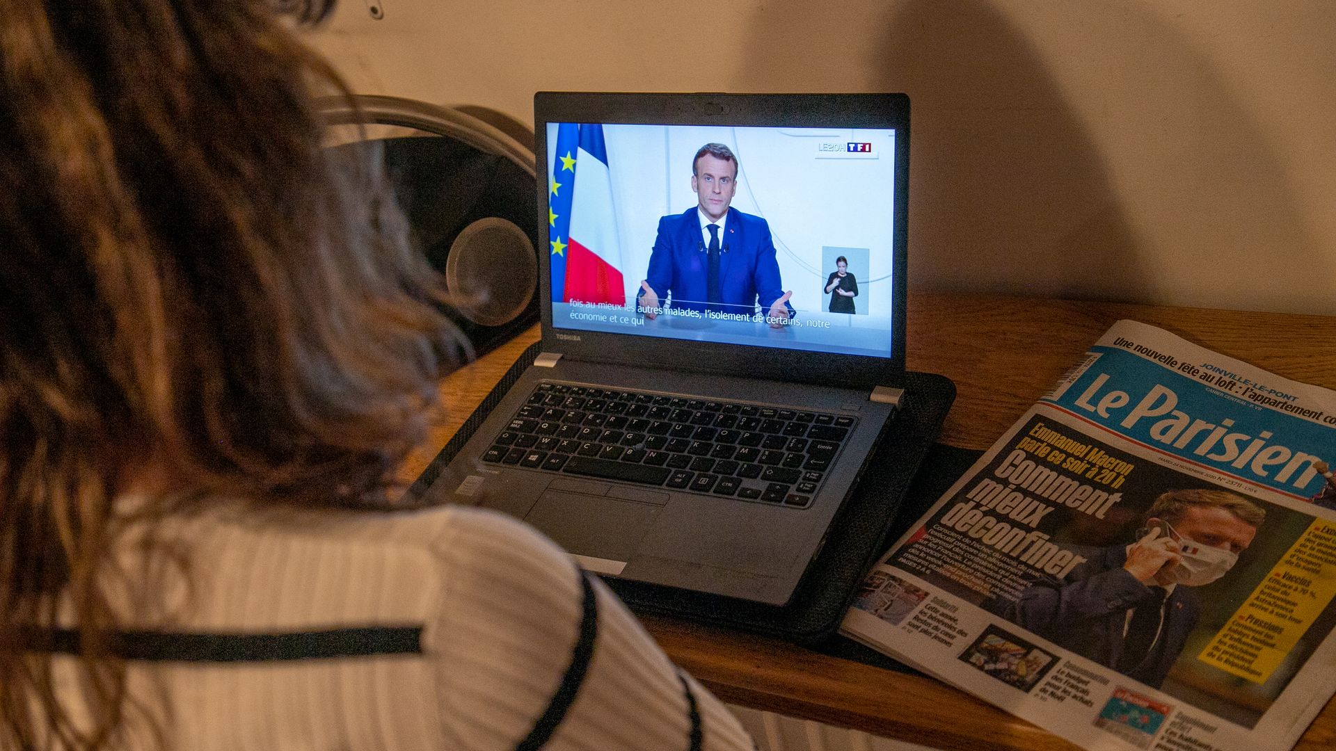Photo of a person watching Emmanuel Macron's televised address on a laptop screen