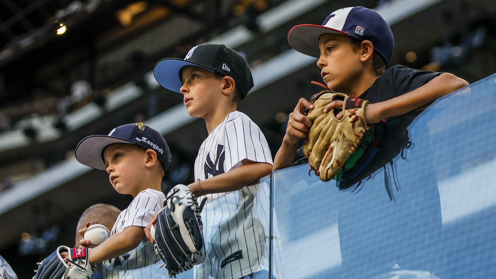 Young Yankees fans and Rangers fans stand at Globe Life Field