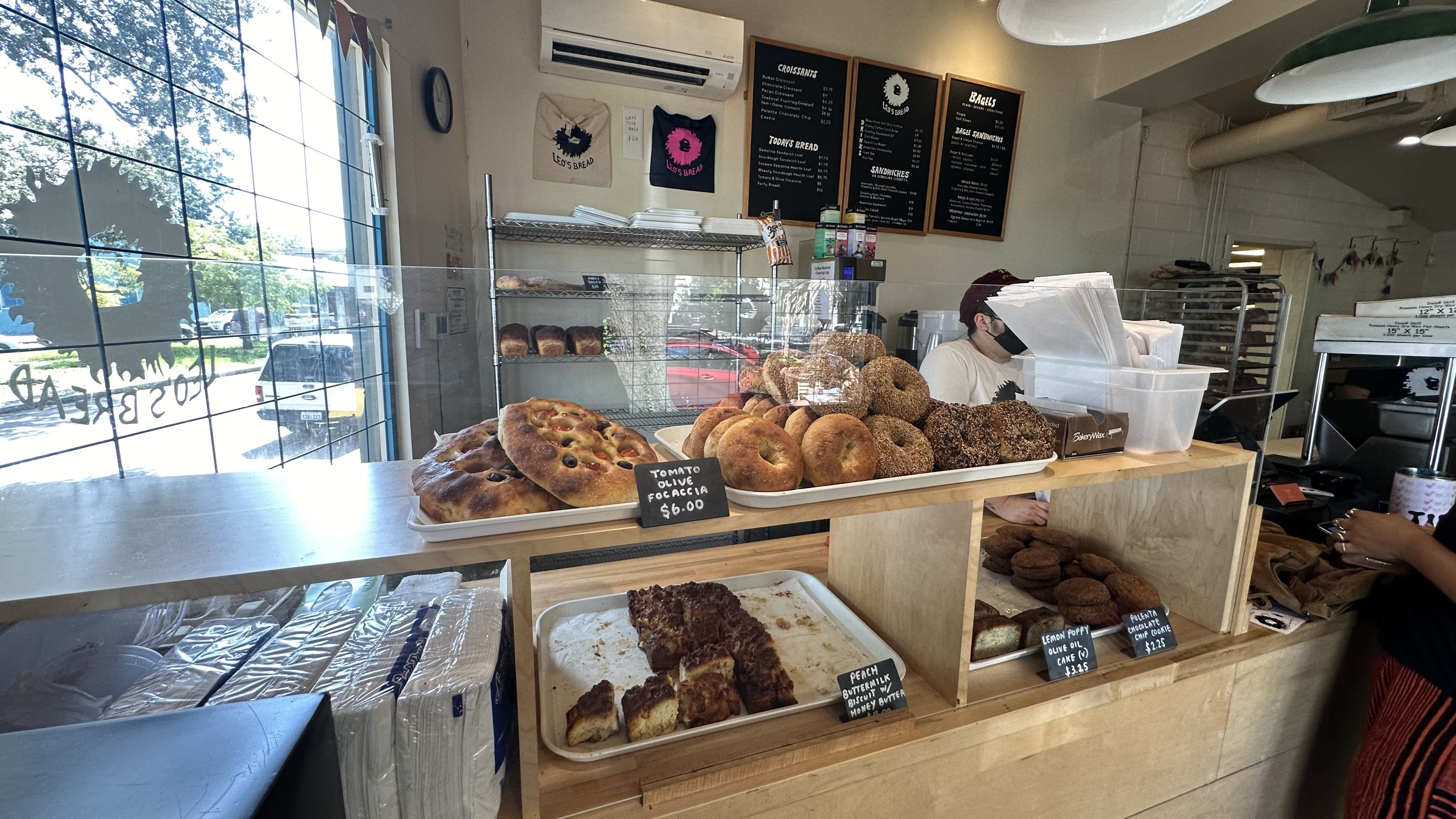 The interior of a bakery. Stacks of bagels and other baked goods sit in a display case.