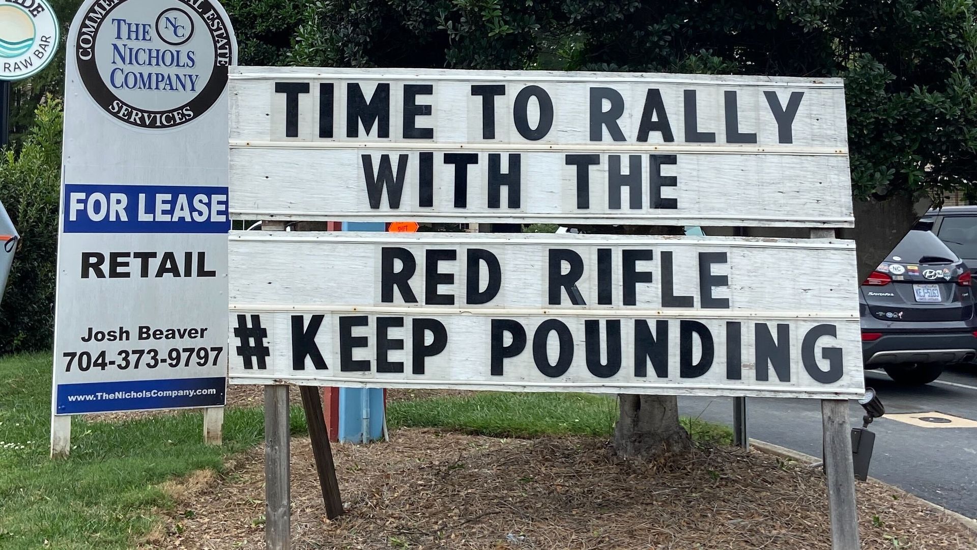 Sign outside restaurant says "Time to rally with the red rifle"