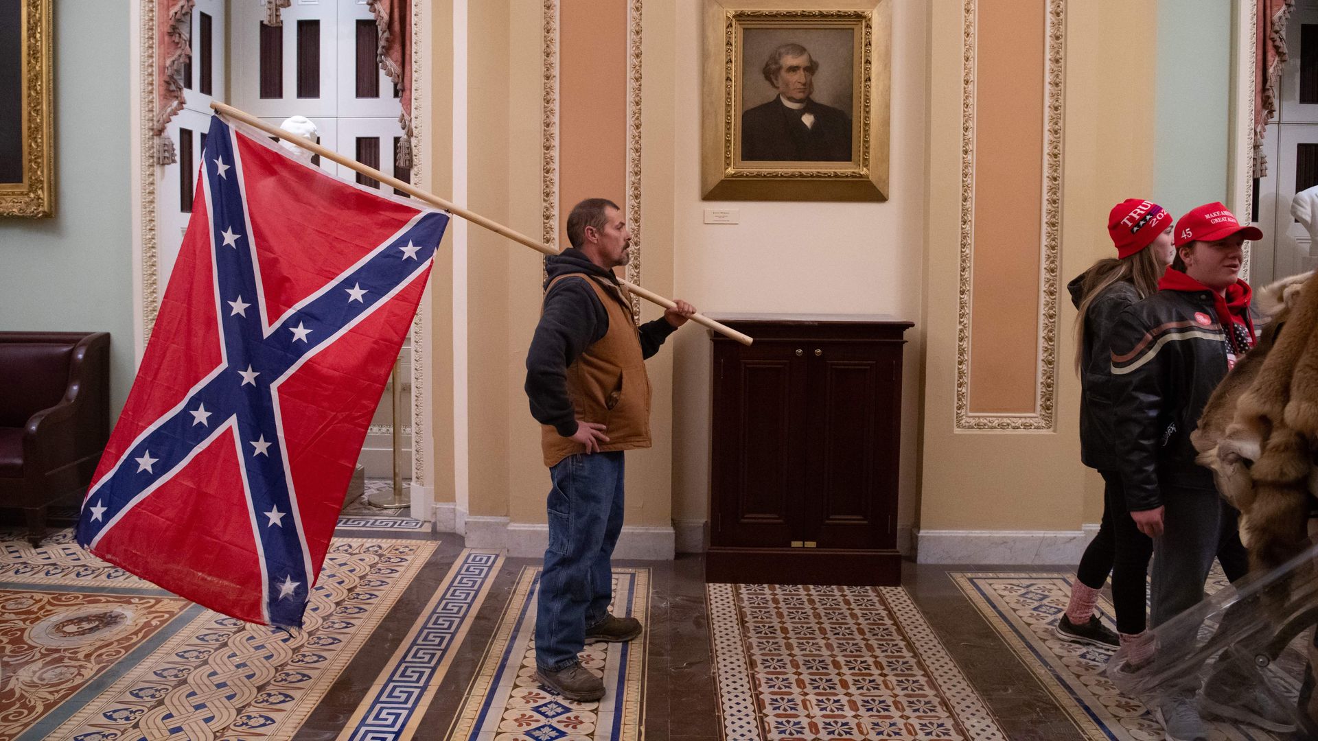 A supporter of Former President Trump holds a Confederate flag outside the Senate Chamber after breaching the US Capitol in Washington, DC, January 6, 2021. 