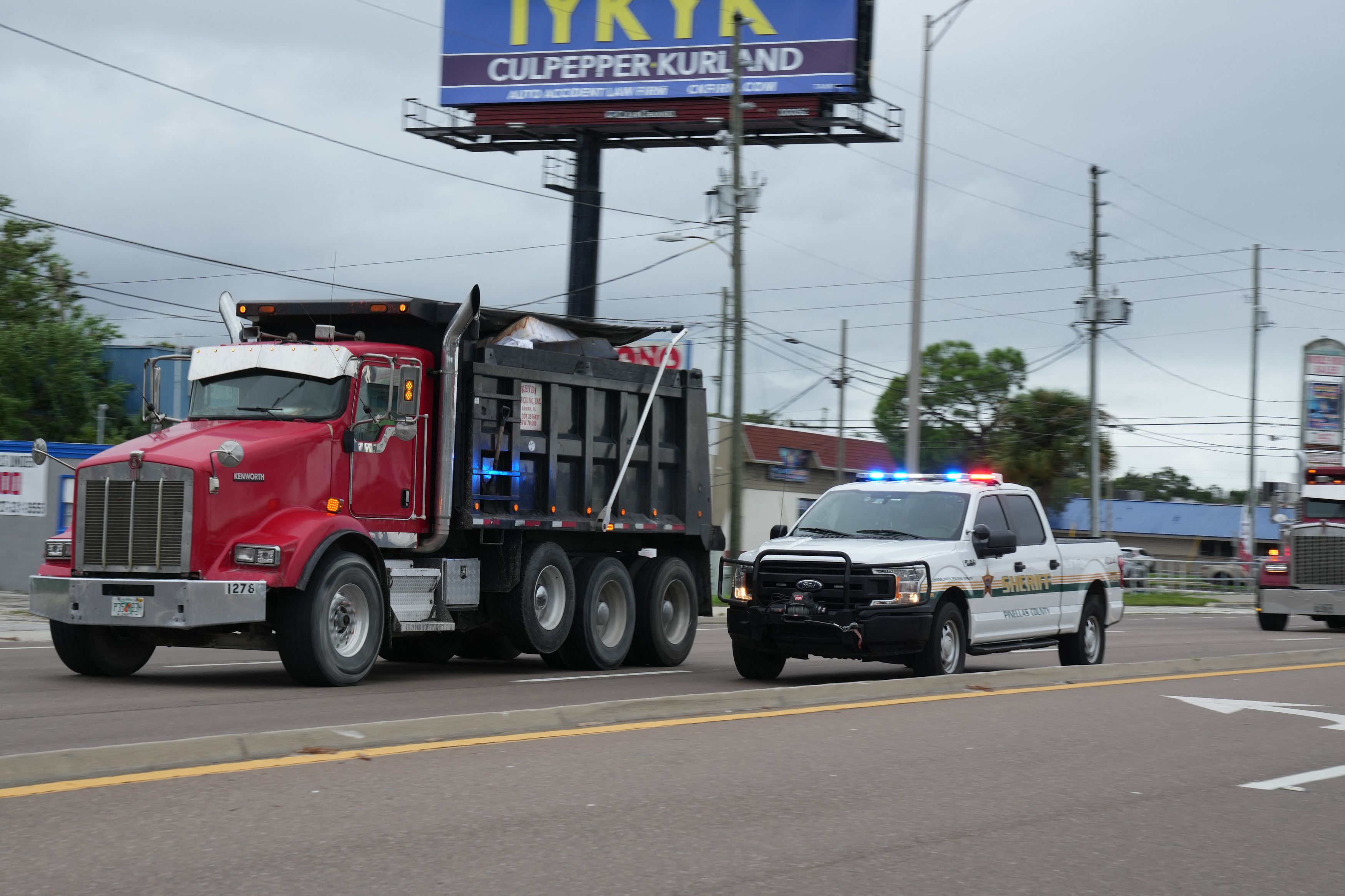 Pinellas County Sheriff's Deputies escort dump trucks filled with debris from Hurricane Helene to a landfill in Clearwater, Florida on October 6, 2024. Florida's governor has declared a state of emergency on Saturday as forecasters warned that Hurricane Milton is expected to make landfall later this