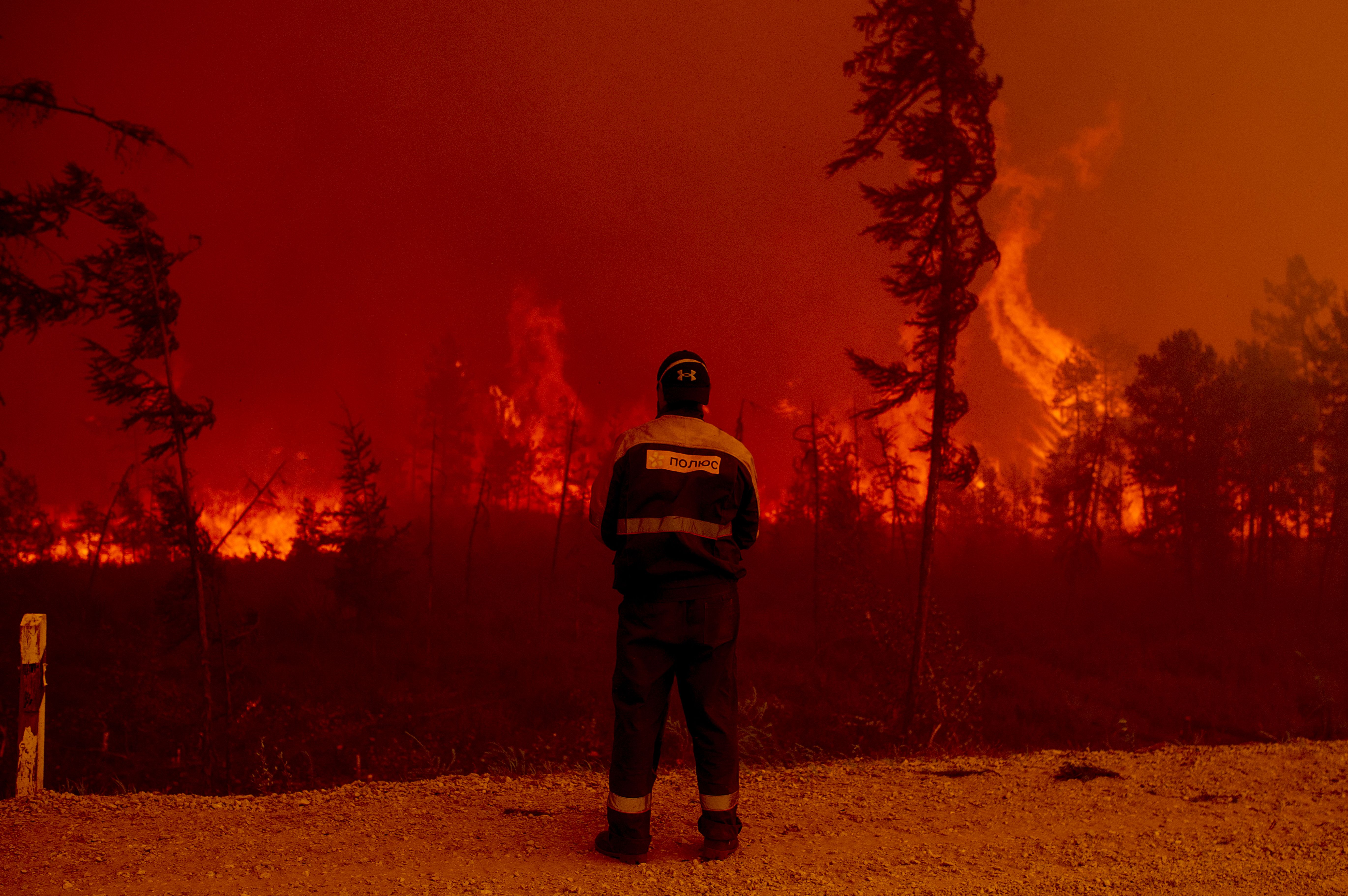 A firefighter watches forrest burn in Siberia 