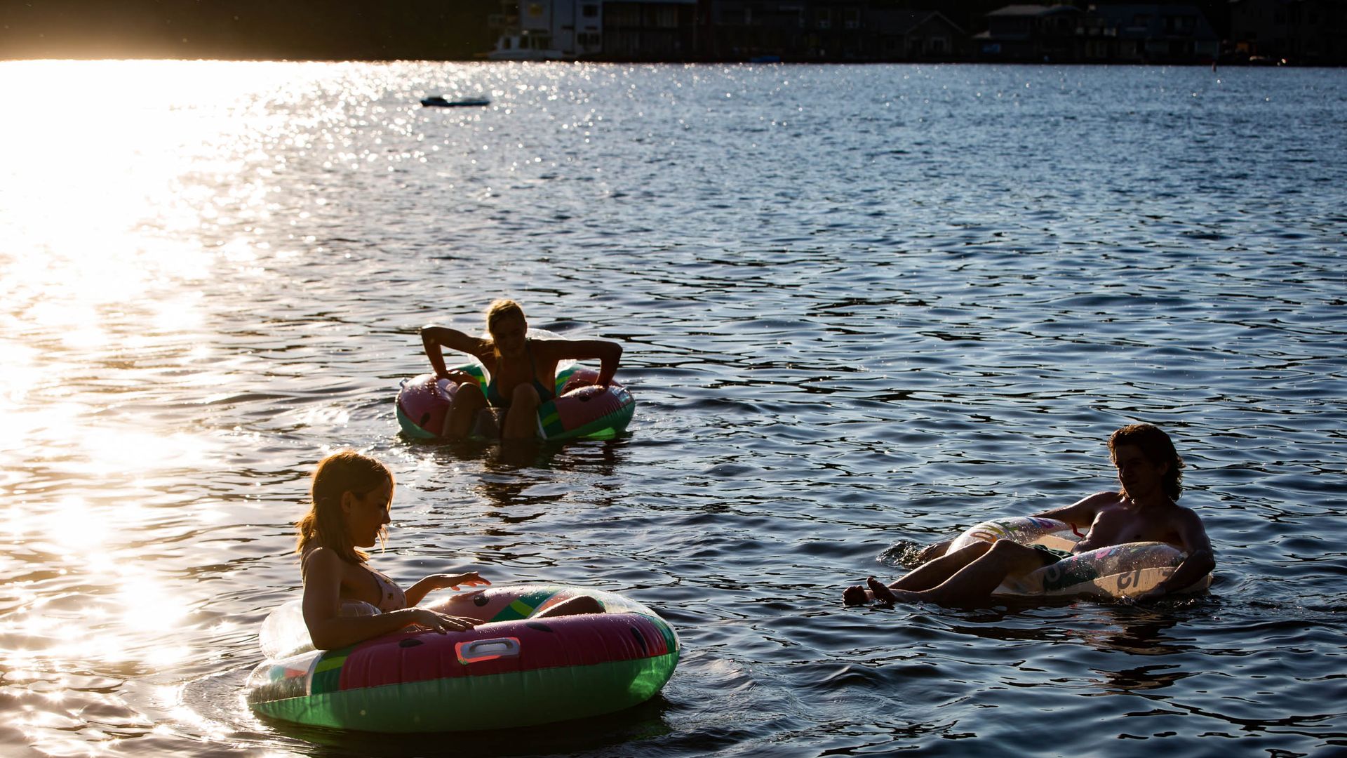 A photo of three people in intertubes along the Willamette River in Portland.