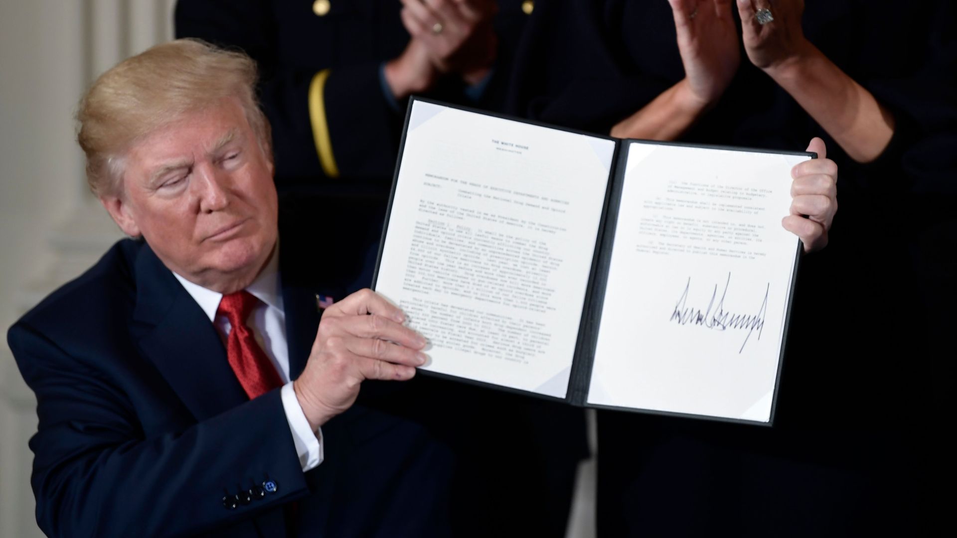 President Trump holding up a signed memo