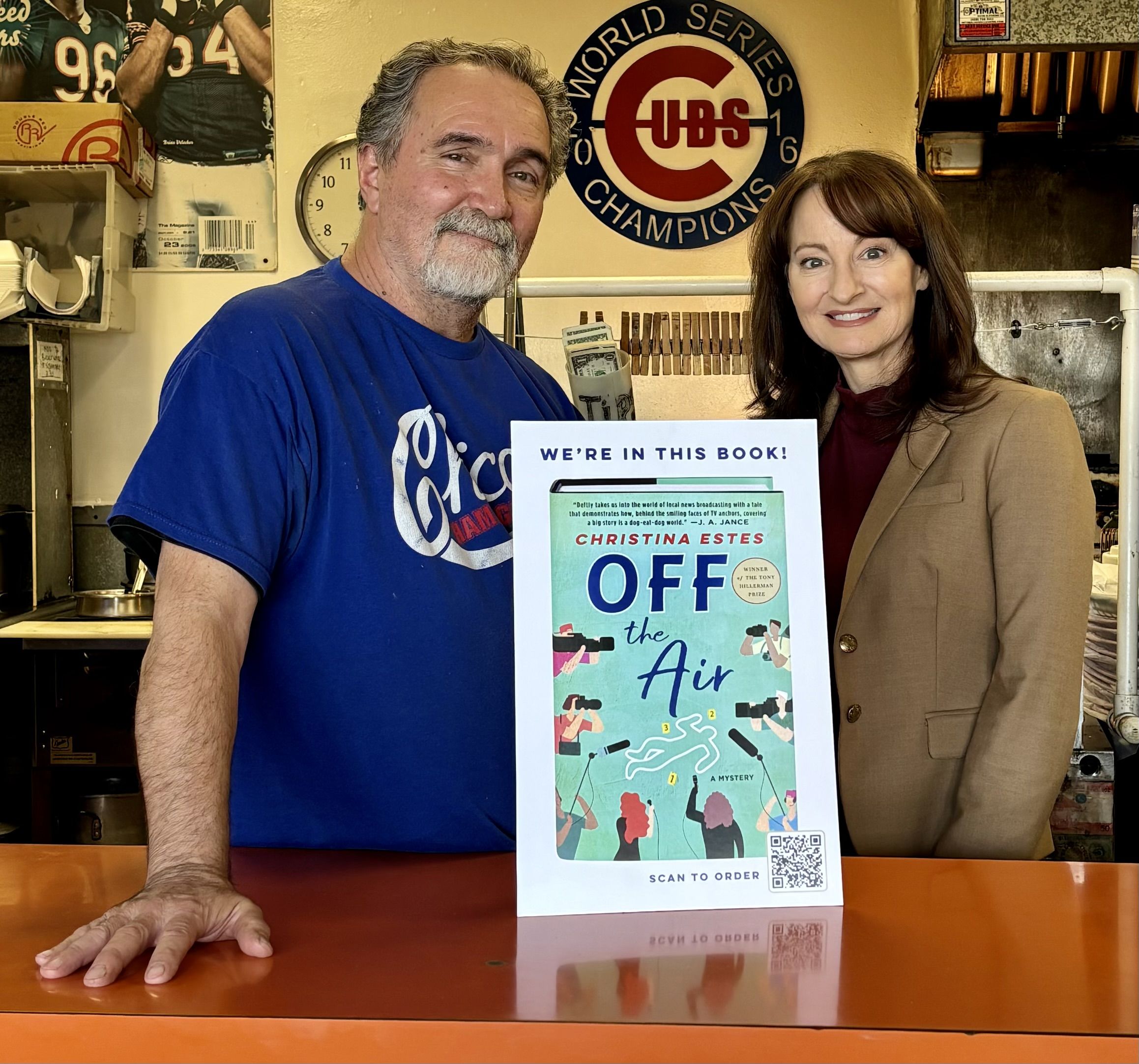 Two people standing next to a sign.