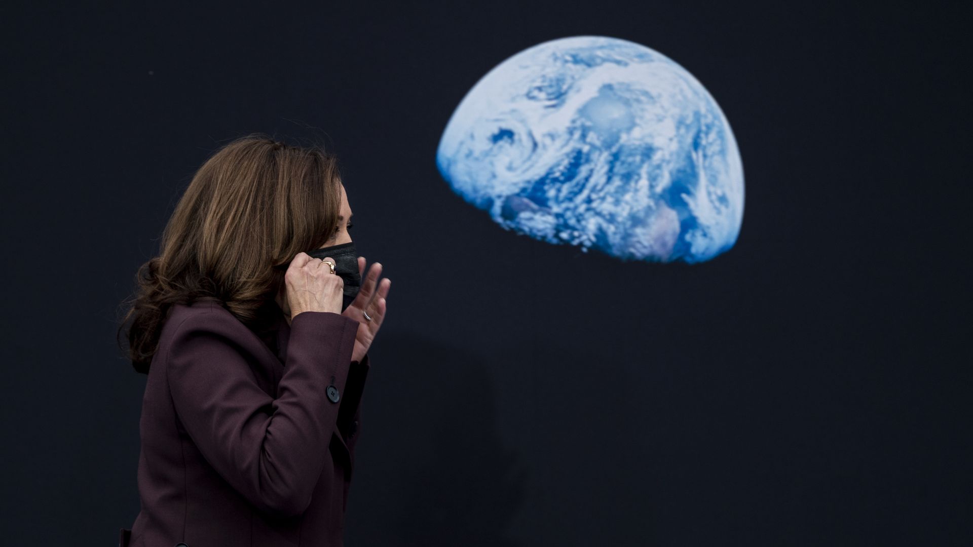 Vice President Kamala Harris is seen walking past a photo of the moon as she enters the inaugural meeting of the National Space Council.