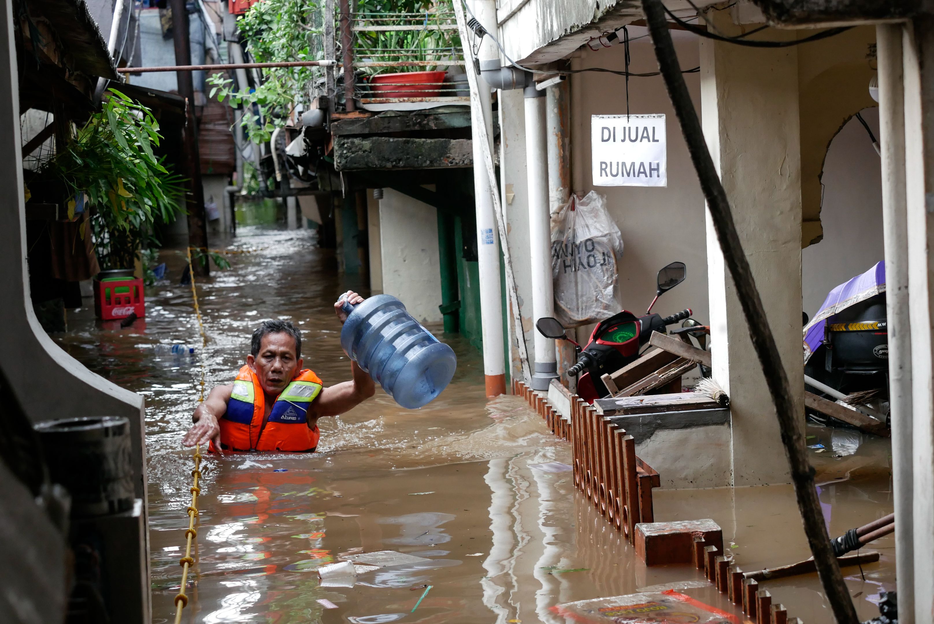 A resident walks in a flooded area following heavy rains at Kemang in Jakarta, Indonesia 