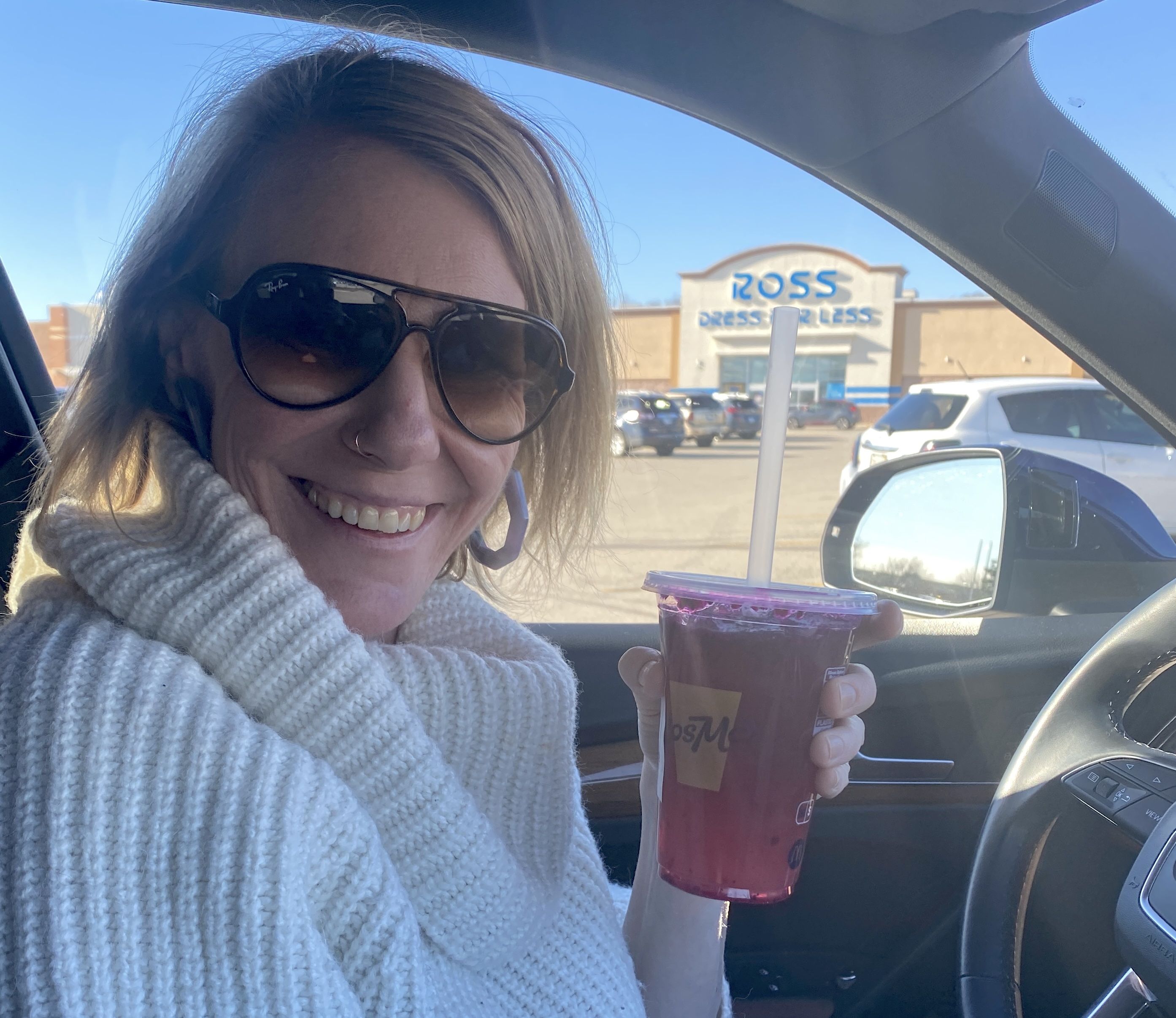 Woman holding bright purple drink.
