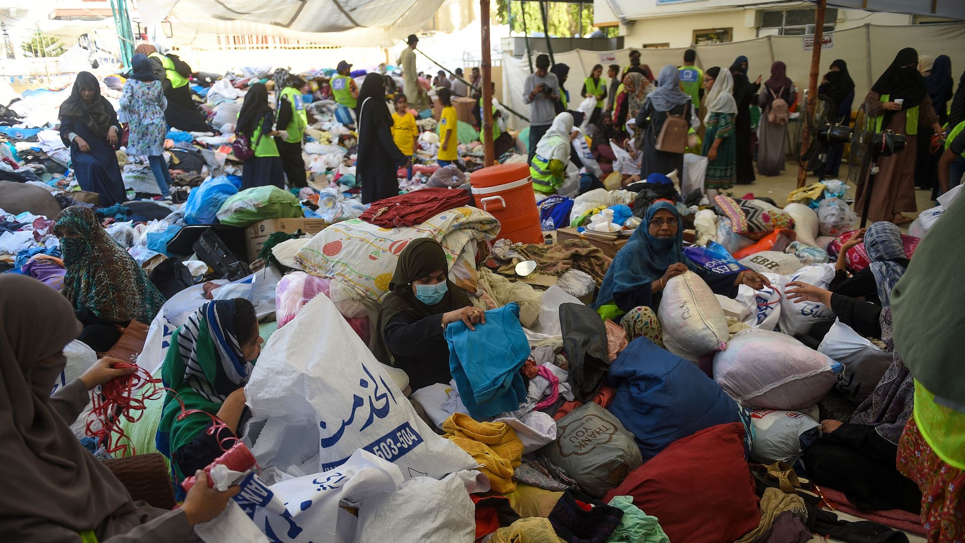 Volunteers of the Charity Al-Khidmat Foundation prepare relief bags for flood-affected people in Karachi