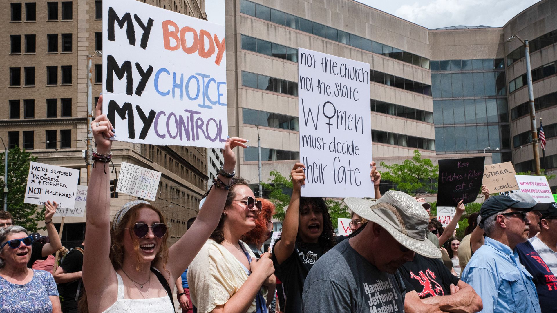 protestors hold up signs in favor of abortion rights.