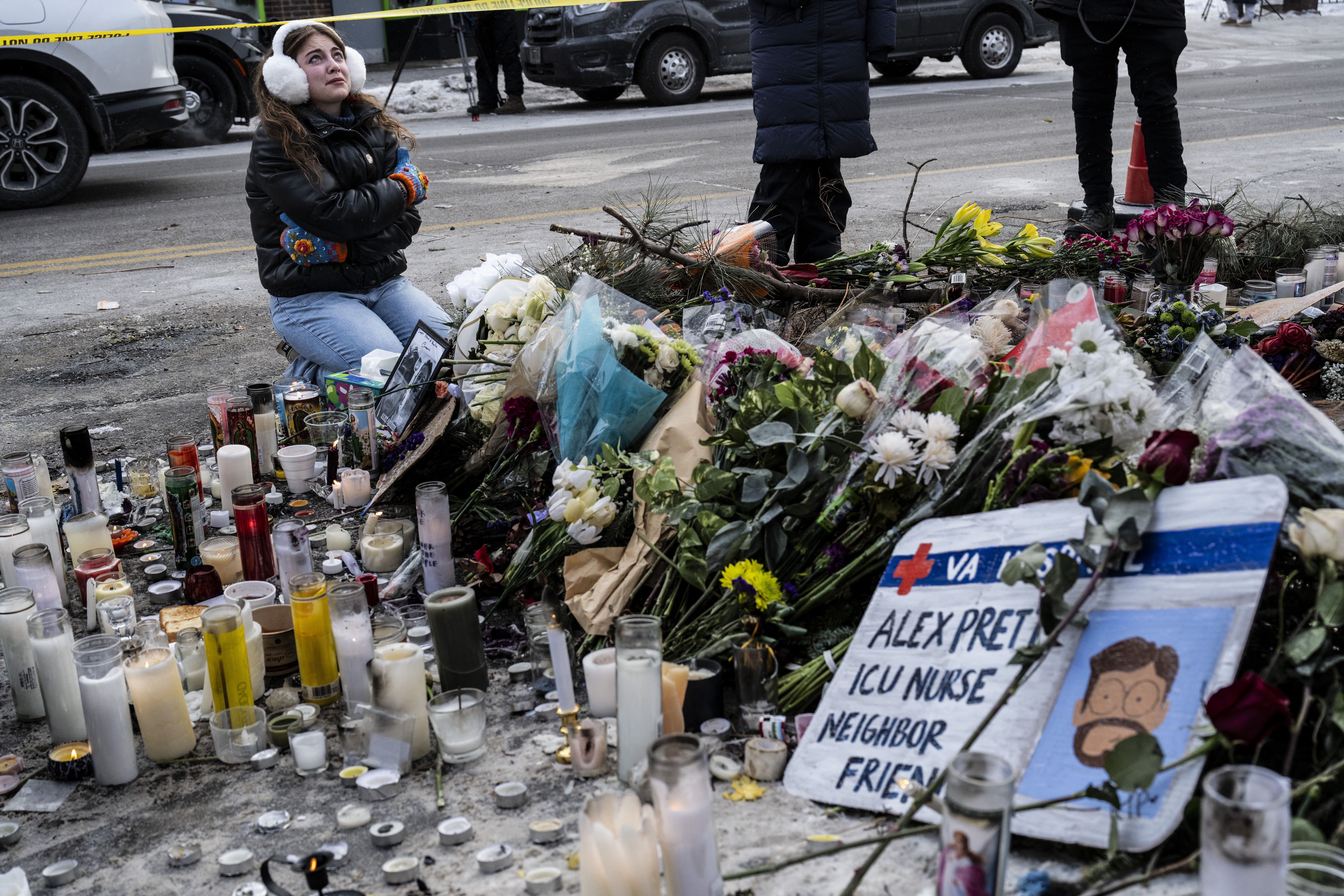 A local resident kneels as she cries while visiting a makeshift memorial in the area where Alex Pretti was shot dead a day earlier by federal immigration agents in Minneapolis, Minnesota, on January 25, 2026. On January 24, federal agents shot dead US citizen Alex Pretti, a 37-year-old ICU nurse, wh