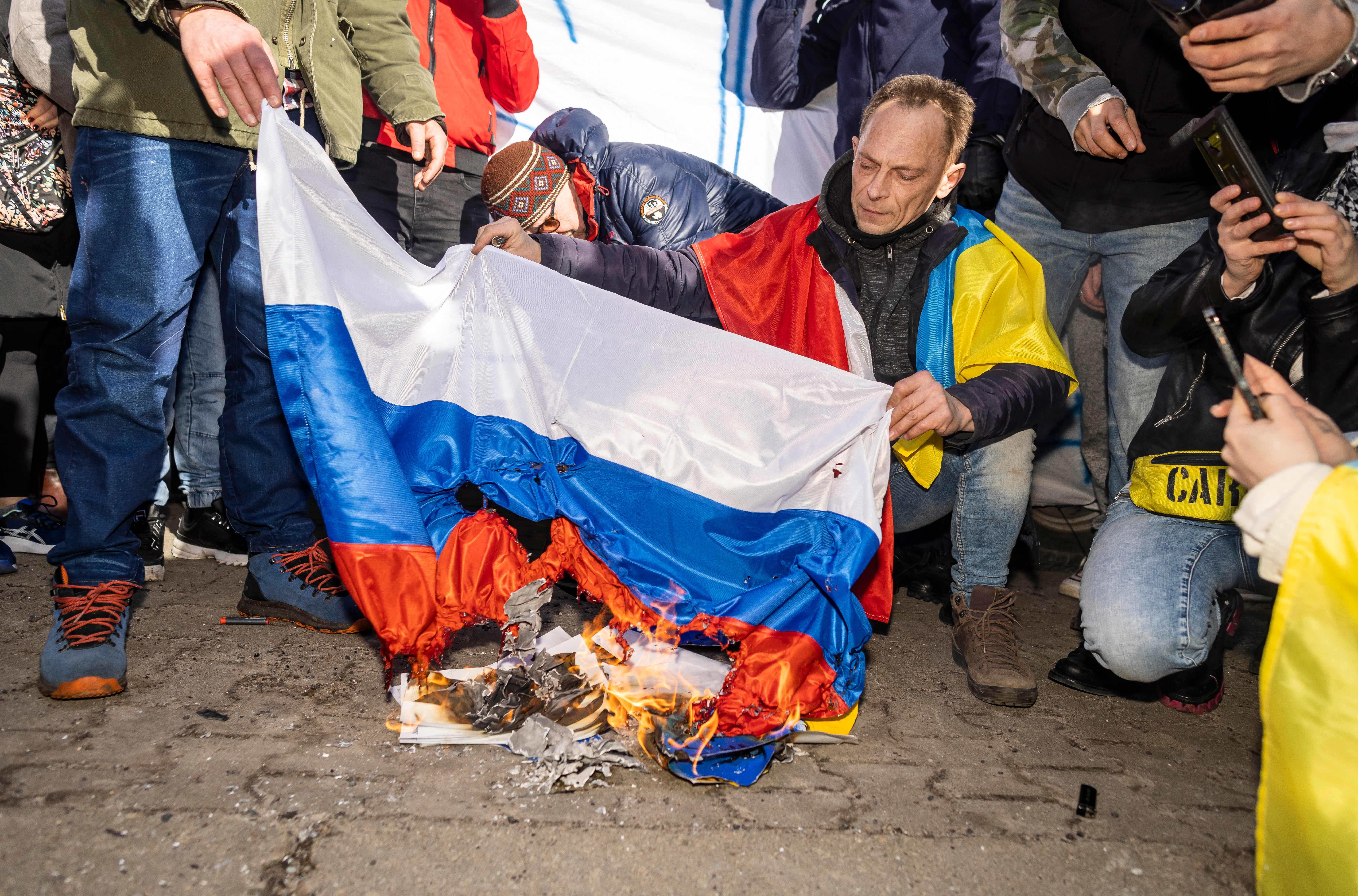 Protesters burning Russia's flag in front of the Russian embassy in Warsaw on Feb. 24.