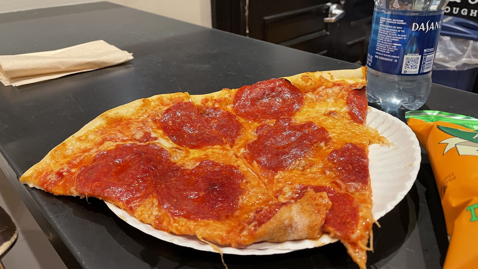 Two slice of pepperoni pizza with loads of grease are on a paper plate on at Dirty Water Dough Co.