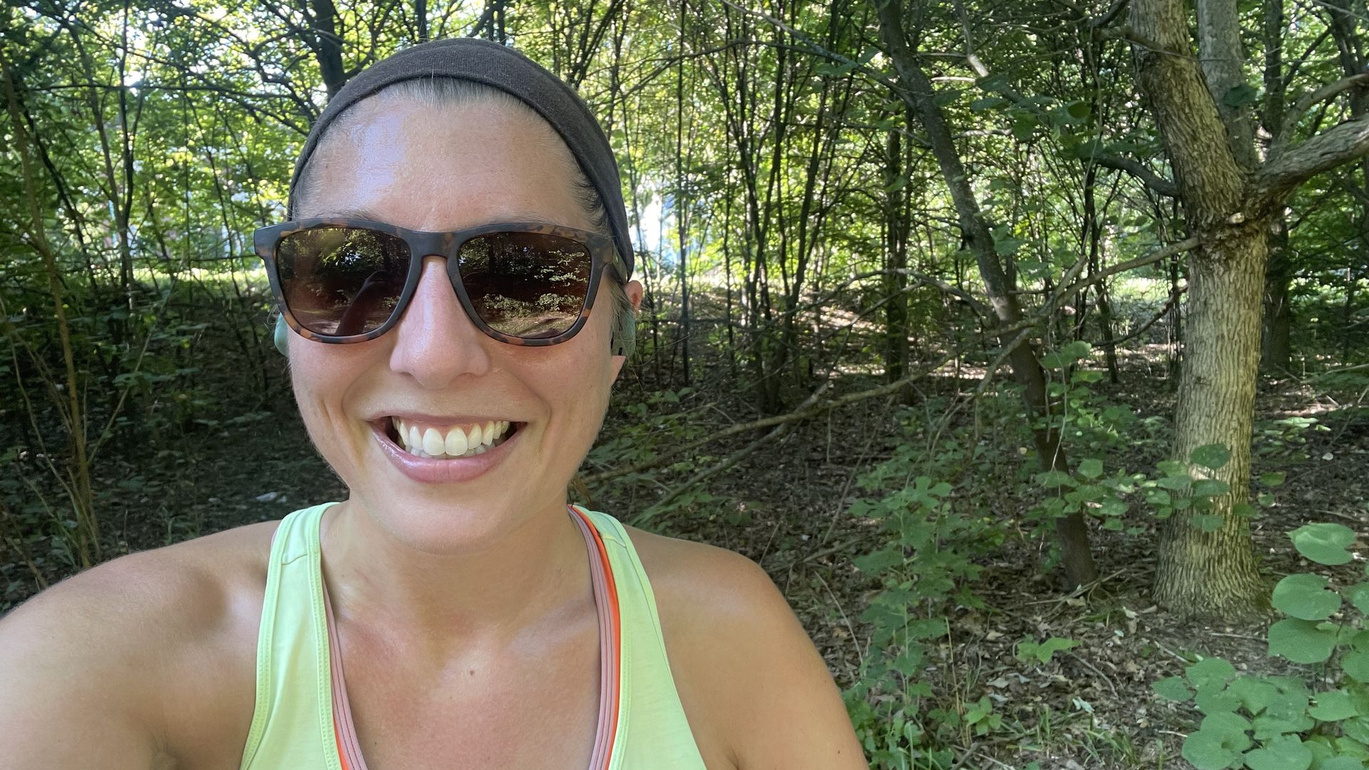 woman standing outside wearing sunglasses, smiling