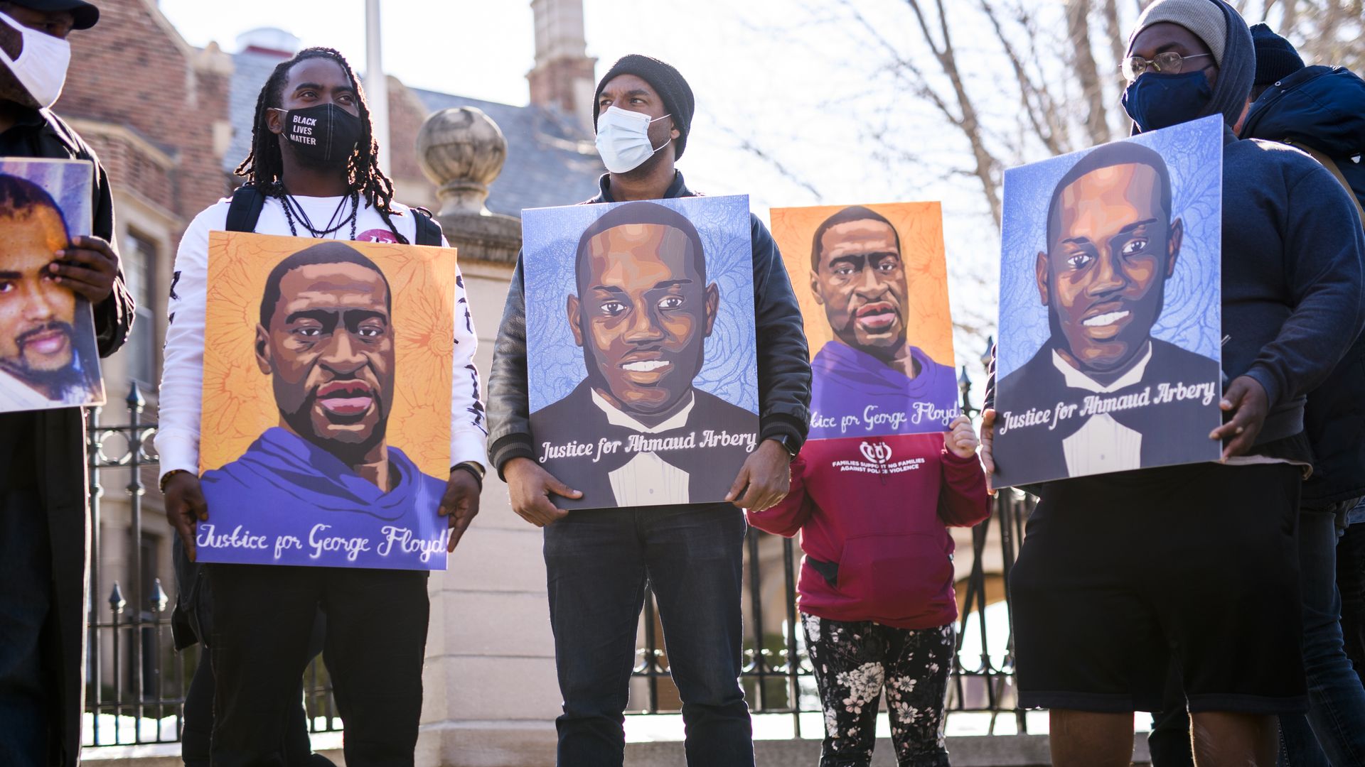 People hold portraits of George Floyd and Ahmaud Arbery during a demonstration