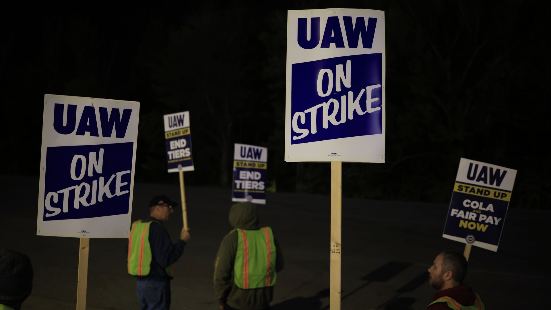 Workers holding picket signs at night