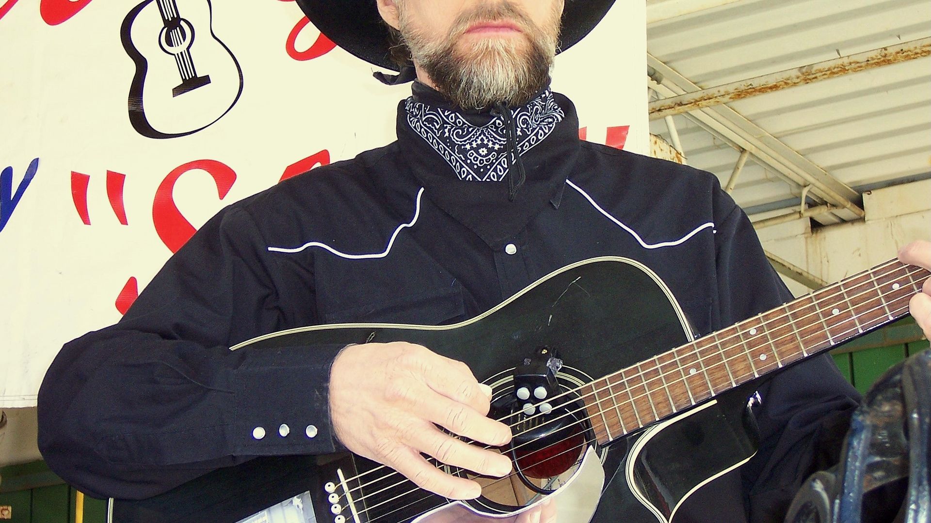 A realistic-looking robot cowboy plays guitar