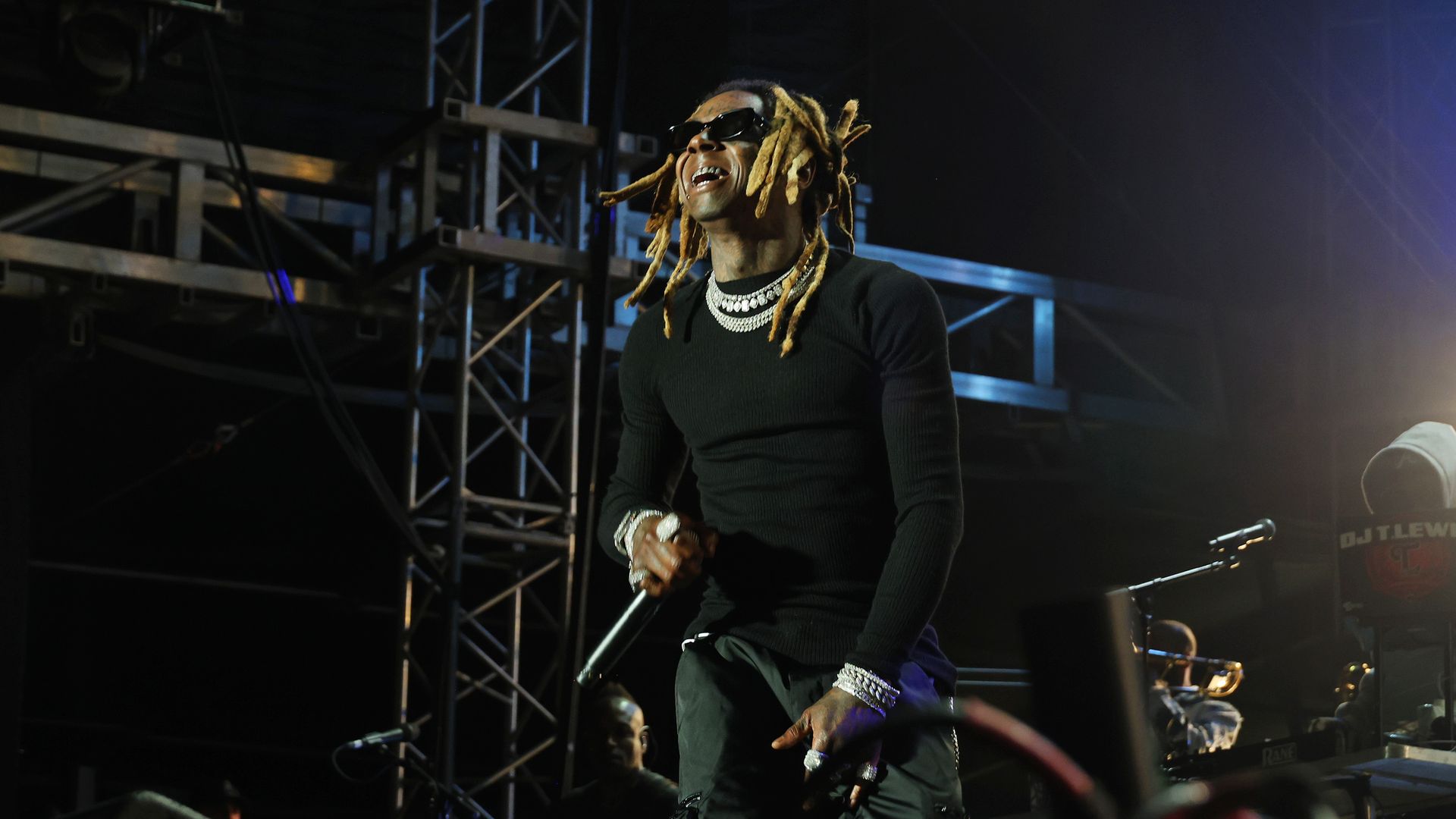 Rapper Lil Wayne performs on stage in all black. 