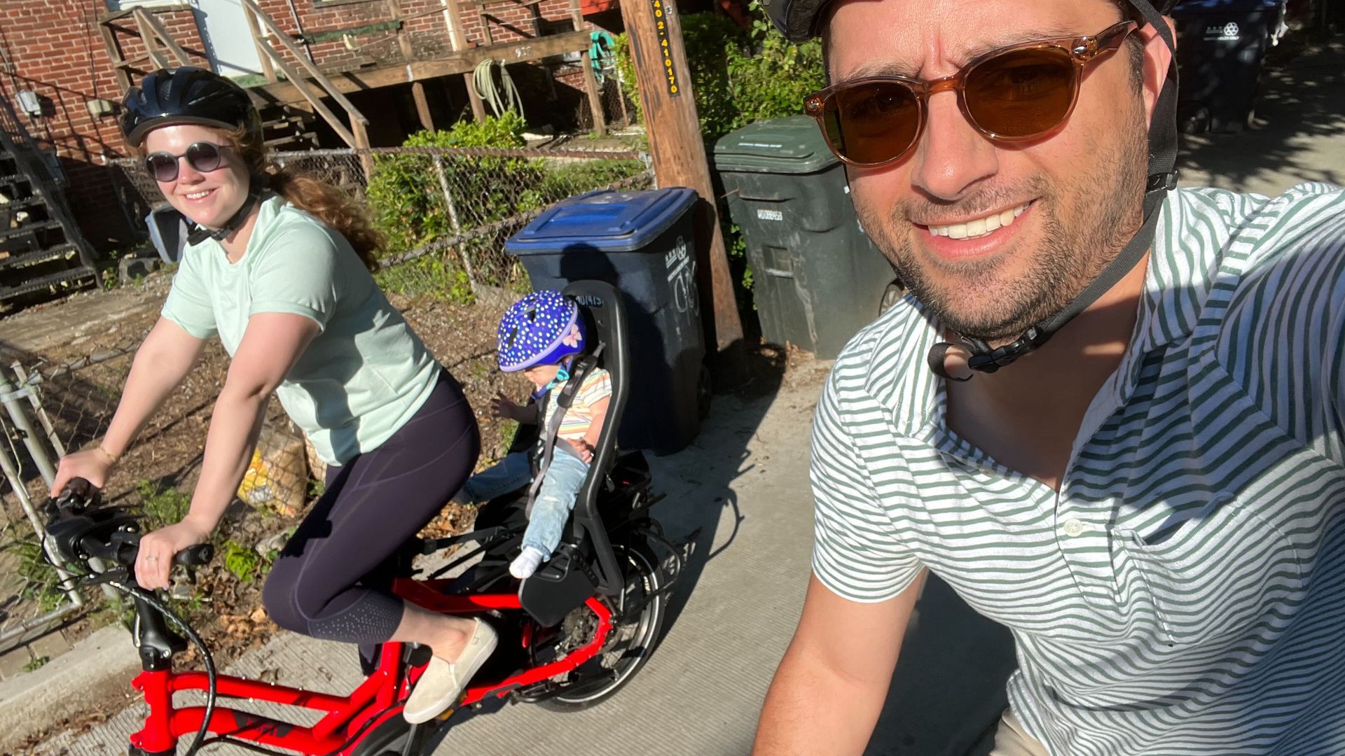 Axios reporter Ashley Gold rides an electric bike with her daughter in tow.