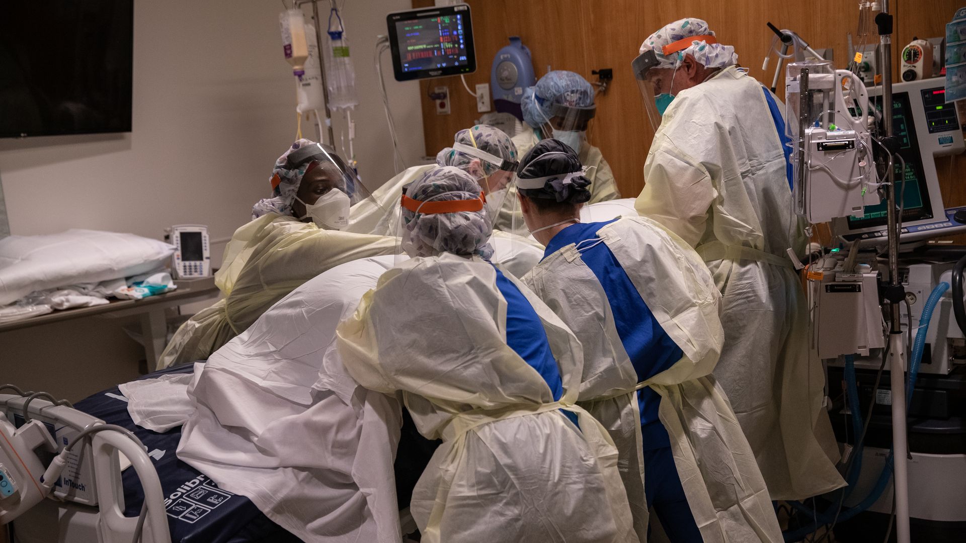 A "prone team," wearing personal protective equipment (PPE), turns a COVID-19 patient onto his stomach in a Stamford Hospital intensive care unit (ICU), on April 24, 2020 in Stamford, Connecticut. 