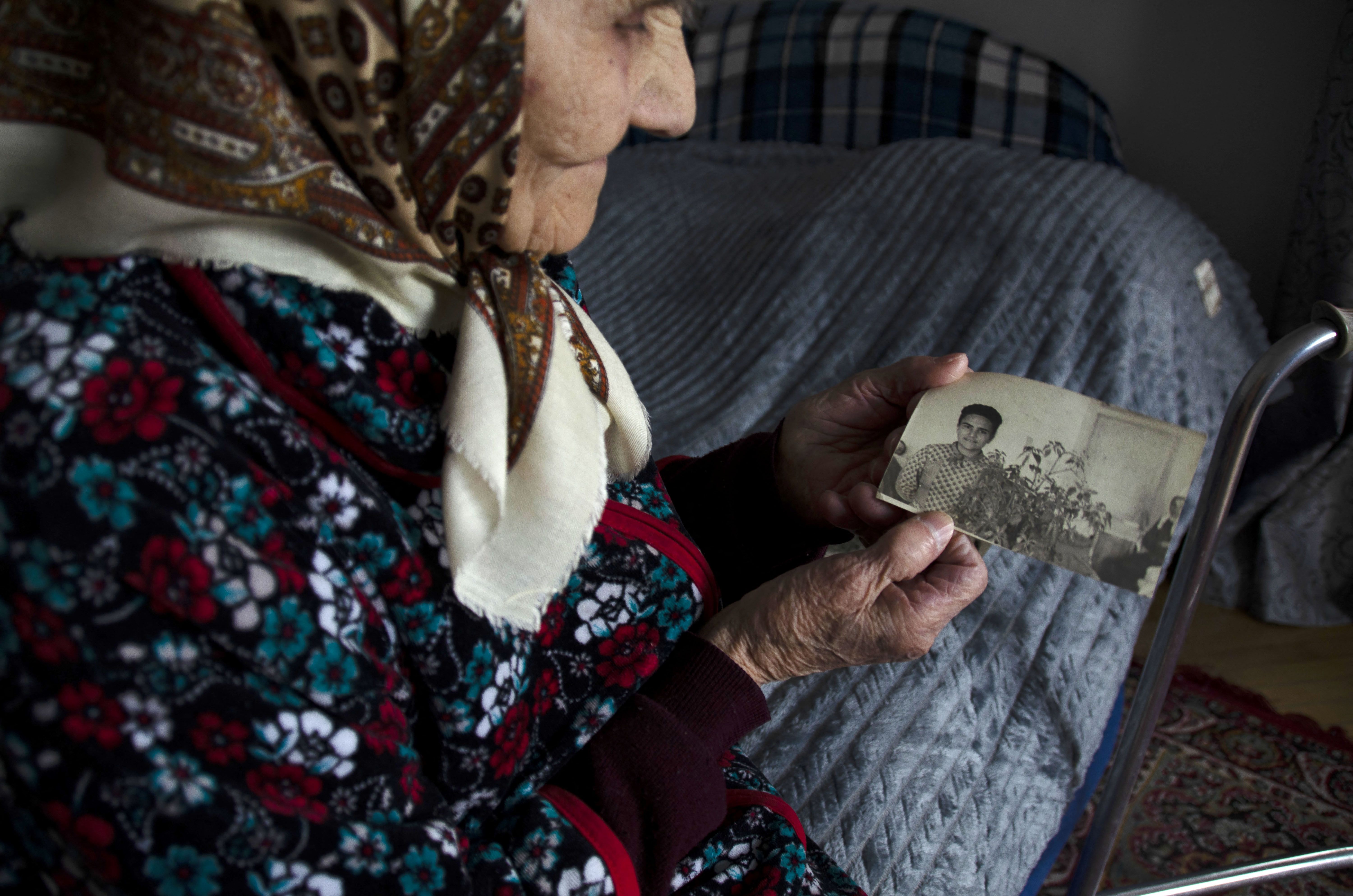 Rozalia Choba, 98, who was a political prisoner in Siberia, shows an old photo of her, at her home in the village of Solonka, outside Lviv, western Ukraine, on March 8.