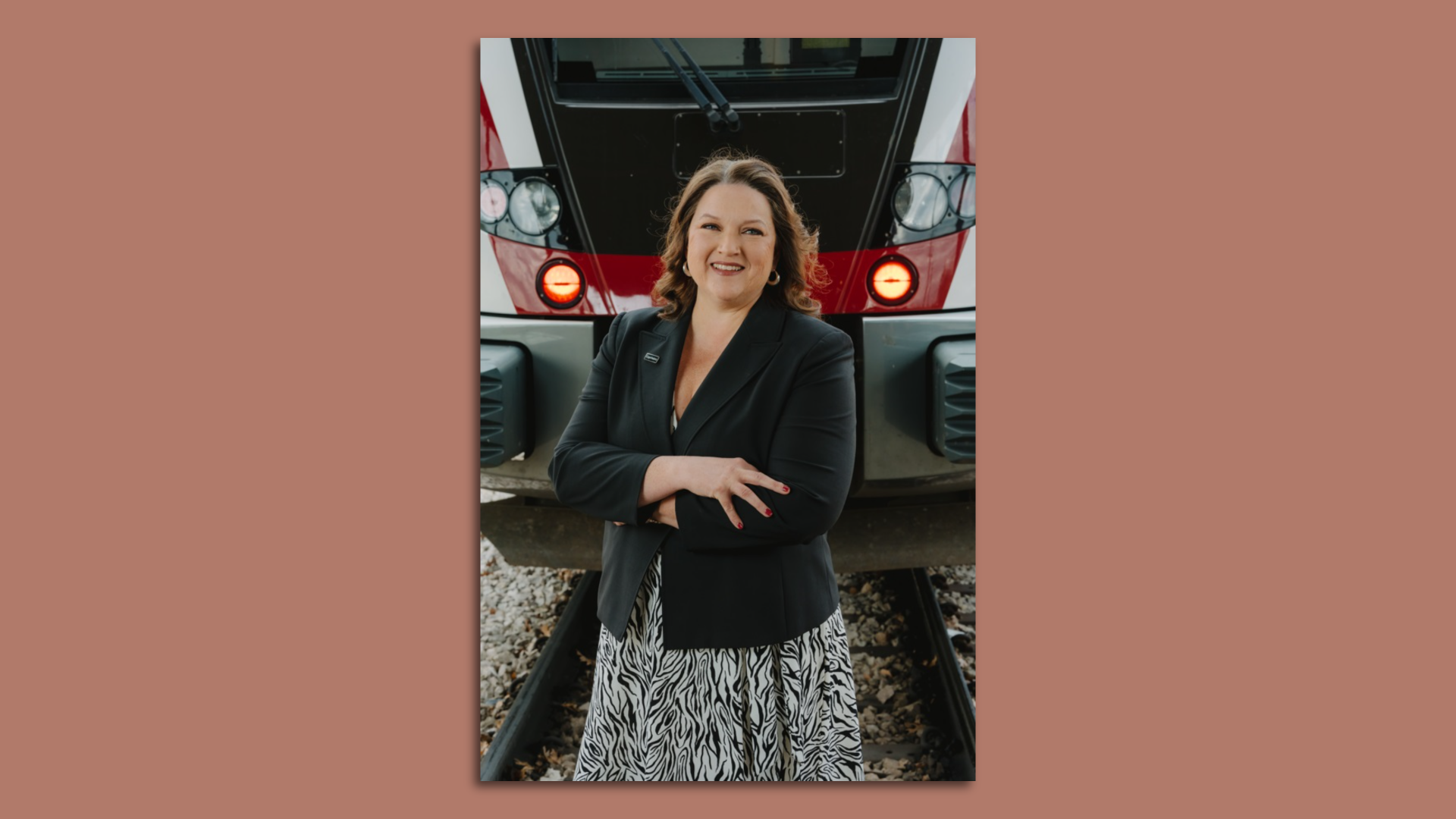 Cap Metro CEO Dottie Watkins stands in front of a train.