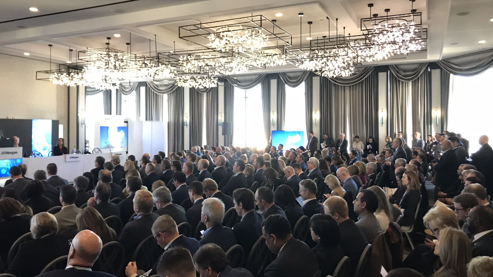 A conference room at the J.P. Morgan Healthcare Conference packed with people wearing suits.