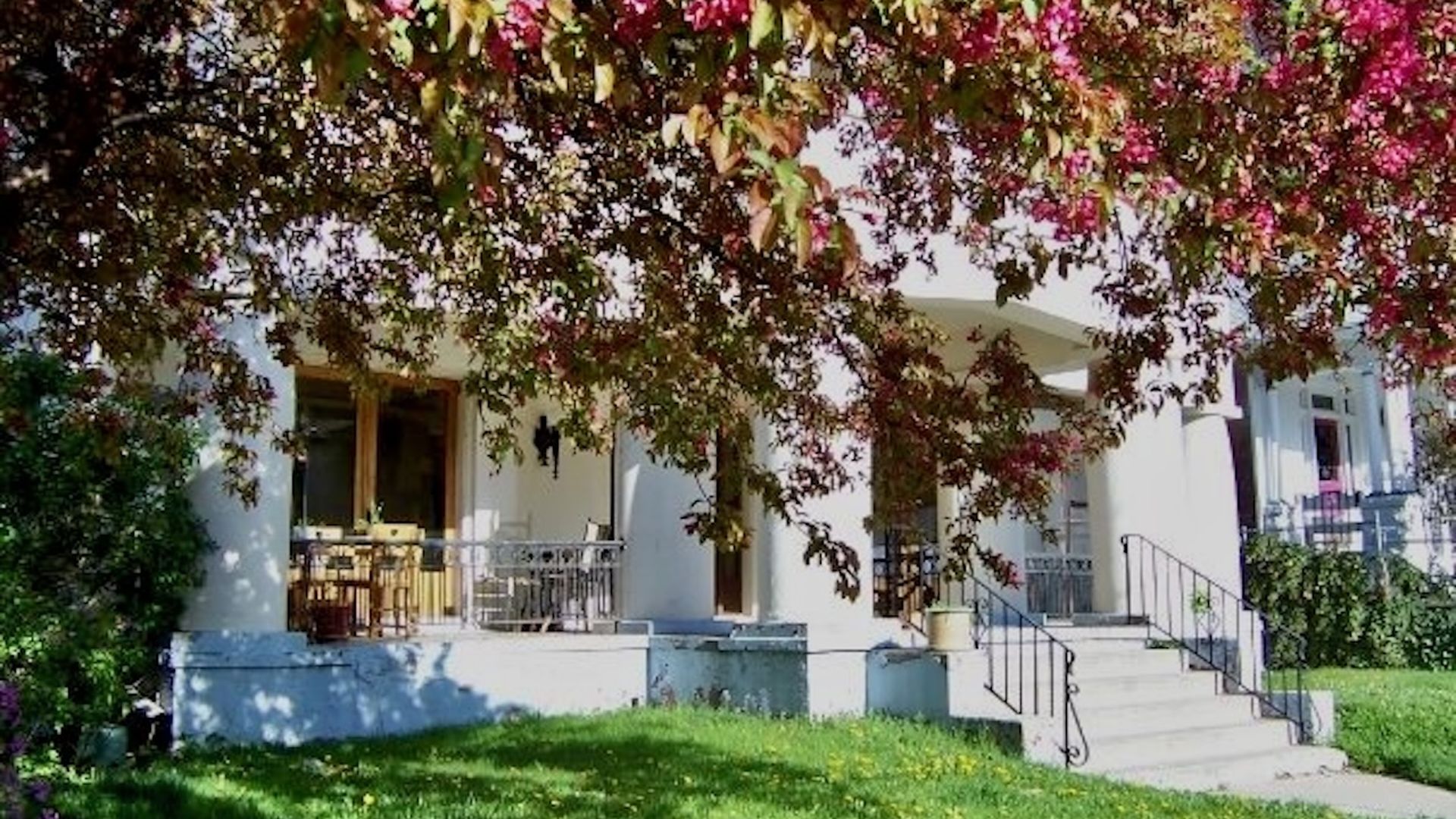 A white porch on a large building with columns.